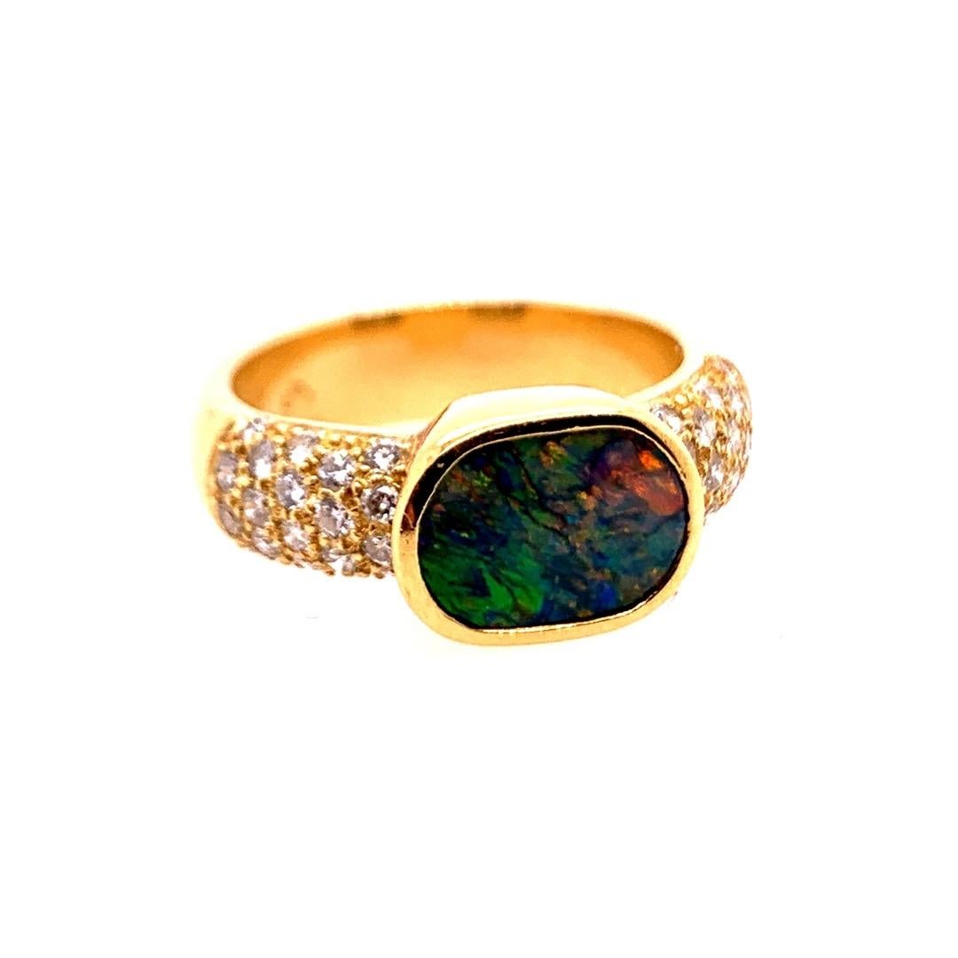 Retro 18k Yellow Gold Ring set with 36 Natural Diamonds (G-VS) weighing approximately 1 carat. The Opal Gemstone is 10x7mm.

Ring is a size 5.75, weighs 7.4 grams, band is 4.8mm width.

Circa 1960.
