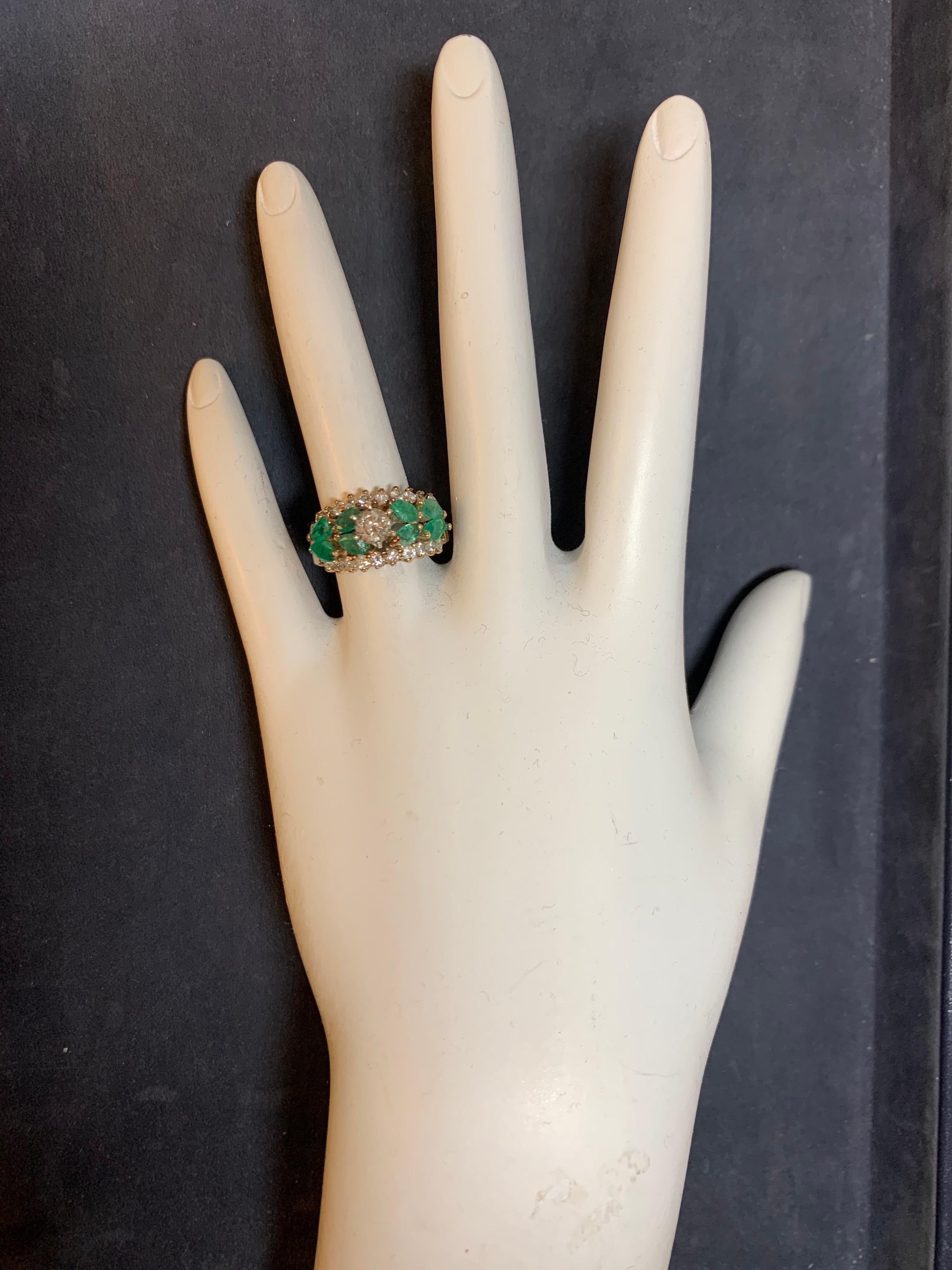 Retro 14k Yellow Gold Ring set with 8 Natural Marquise Emeralds weighing approximately 1 Carat. 

The centerstone is a natural 4.4mm round brilliant diamond weighing approximately 0.38 carats, 