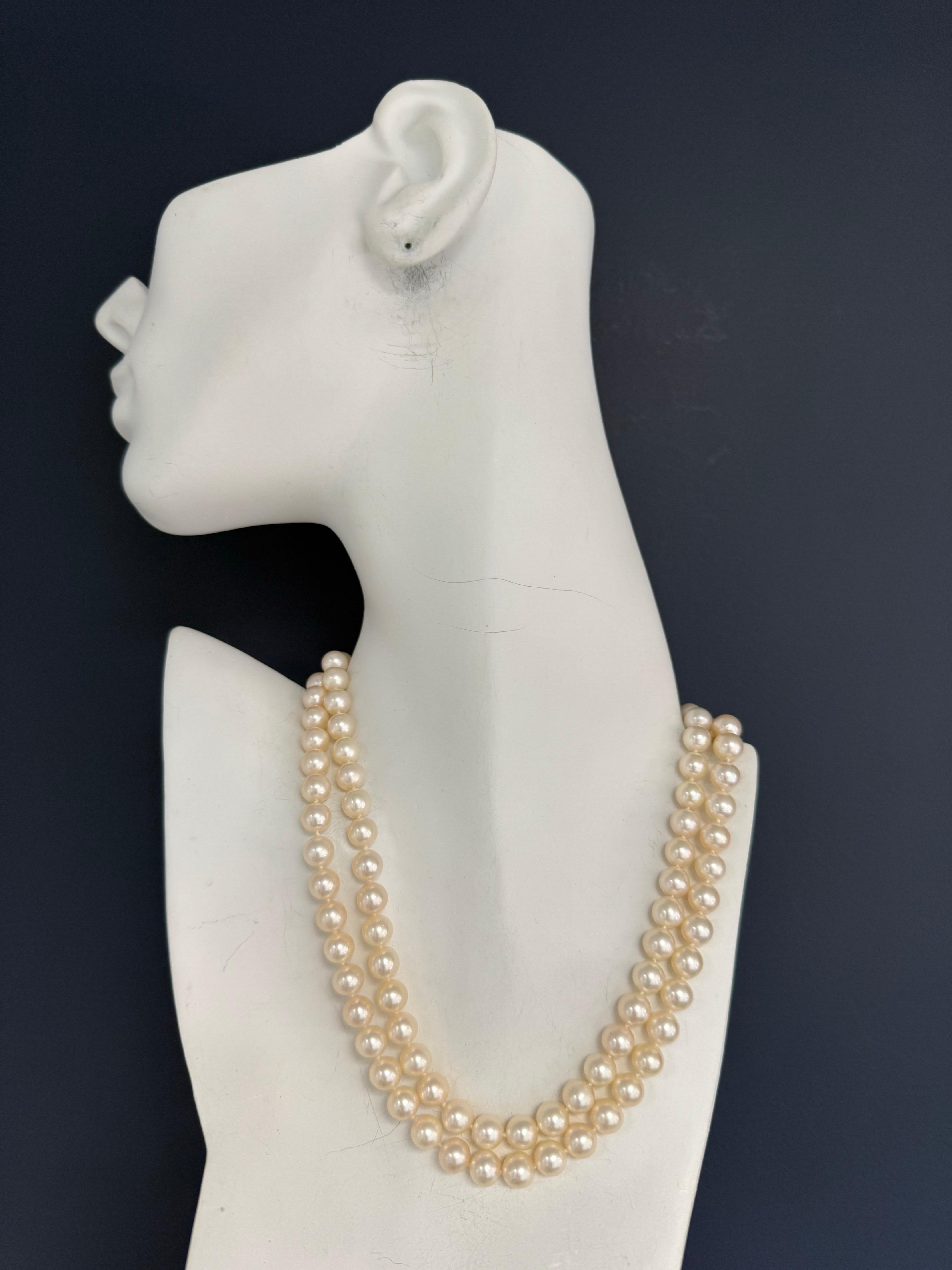 Elegant retro 14 karat yellow gold double-row South Sea pearl necklace, set with 16 natural colorless round brilliant diamonds totaling approximately 0.40 carats. The pearls measure about 7.6 mm each, with 47 pearls in the inner strand and 50 pearls