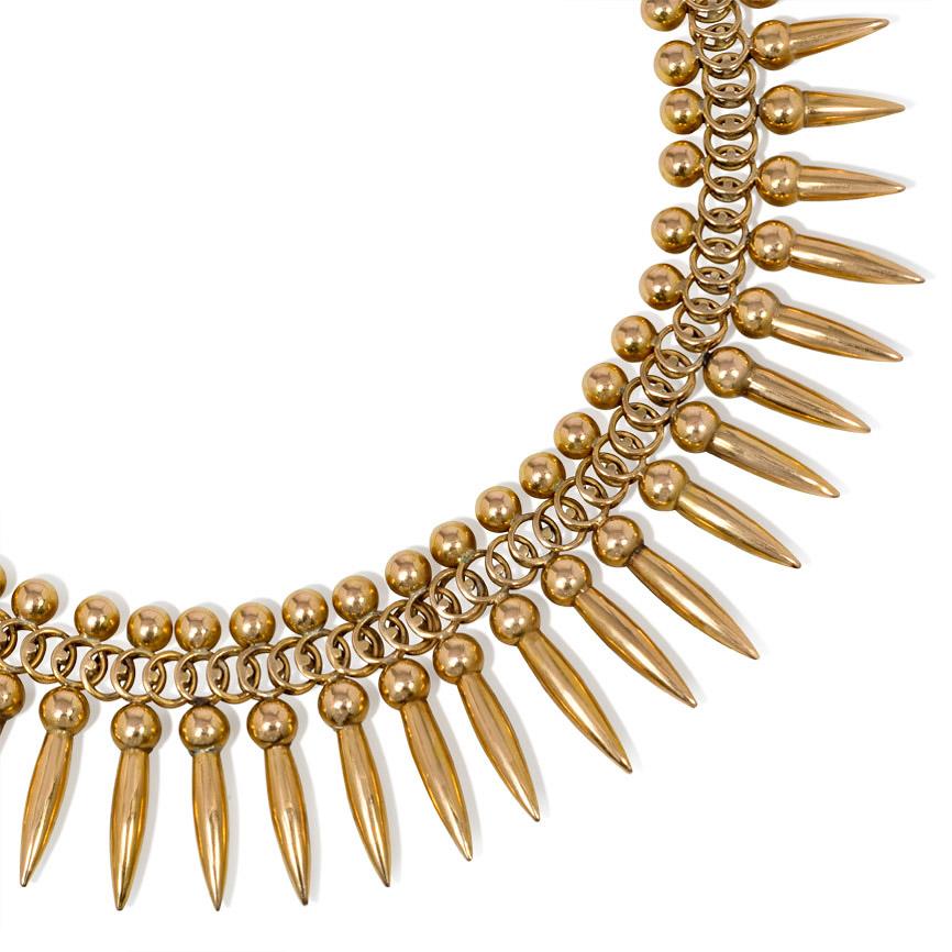 A Retro gold necklace of woven design with a fringe of graduated amphorae pendants, in 18k.

Dimensions: length 16 1/2