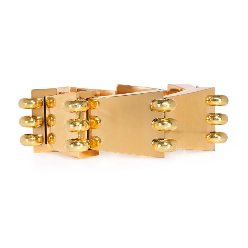 A Retro gold bracelet comprised of overlapping tapered gold segments, each terminating in three gold rings, in 18k.  Numbered 18050.  In pristine condition