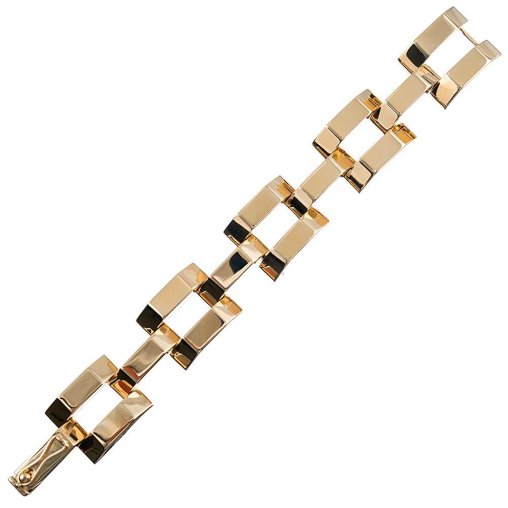 Highly architectural golden links of brightly polished 14 karat yellow gold create this retro bracelet. Its glamorous, chic aesthetic is uncomplicated by gemstones and can be worn with any attire. 7.5 inches long and 7/8 of an inch wide. Signed
