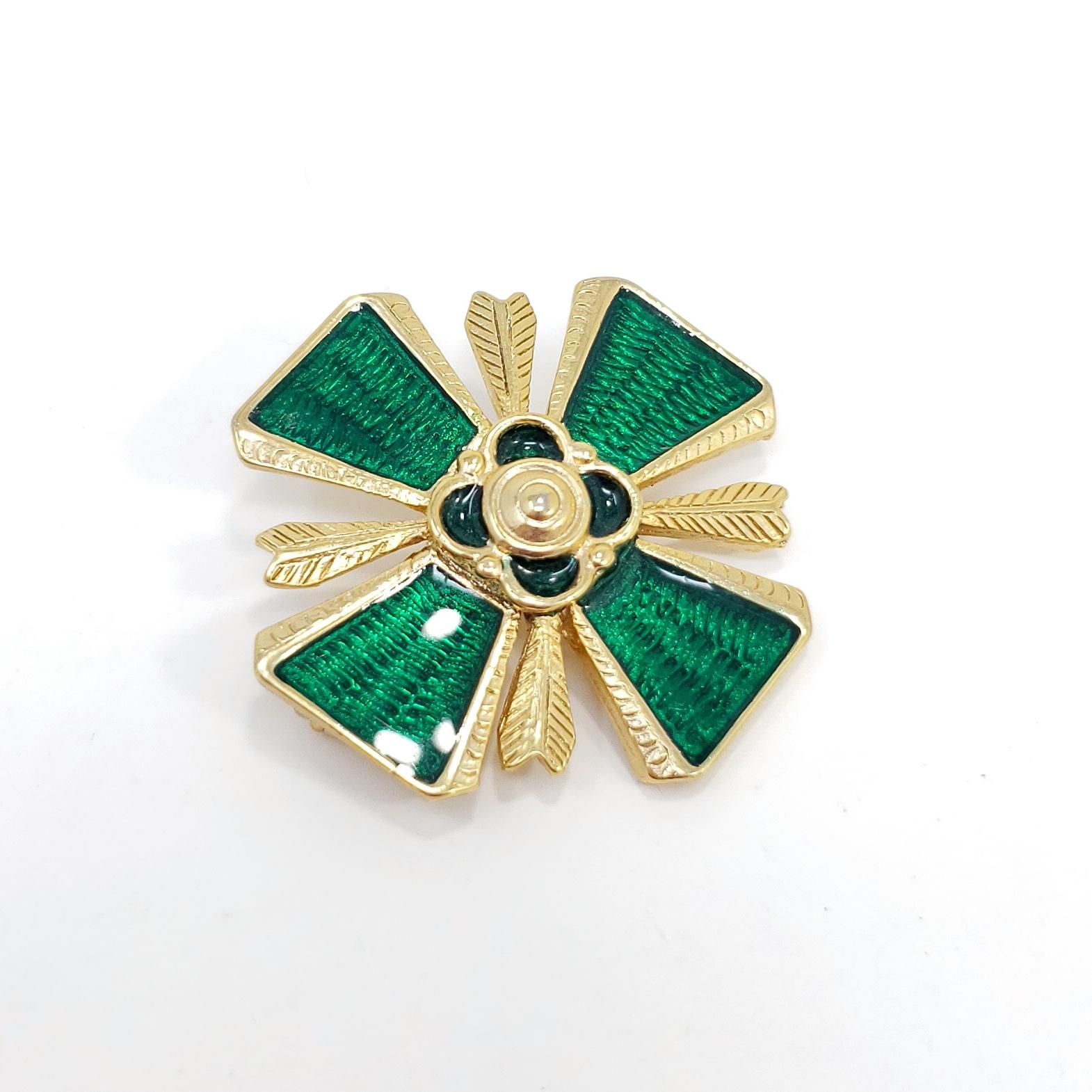 A stylish retro pin, featuring a maltese cross motifs painted with green enamel.

Gold-tone. Circa late 1900s.