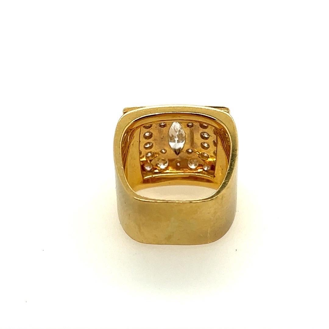 A stunning 1.67 carat (approximate) men's 18k yellow gold natural diamond pinky ring. Set in the center is an approximate 0.55 carat natural marquise diamond, H in color and vs2 in clarity, measuring 8.6x4.5mm.

The ring also is set with 32 natural