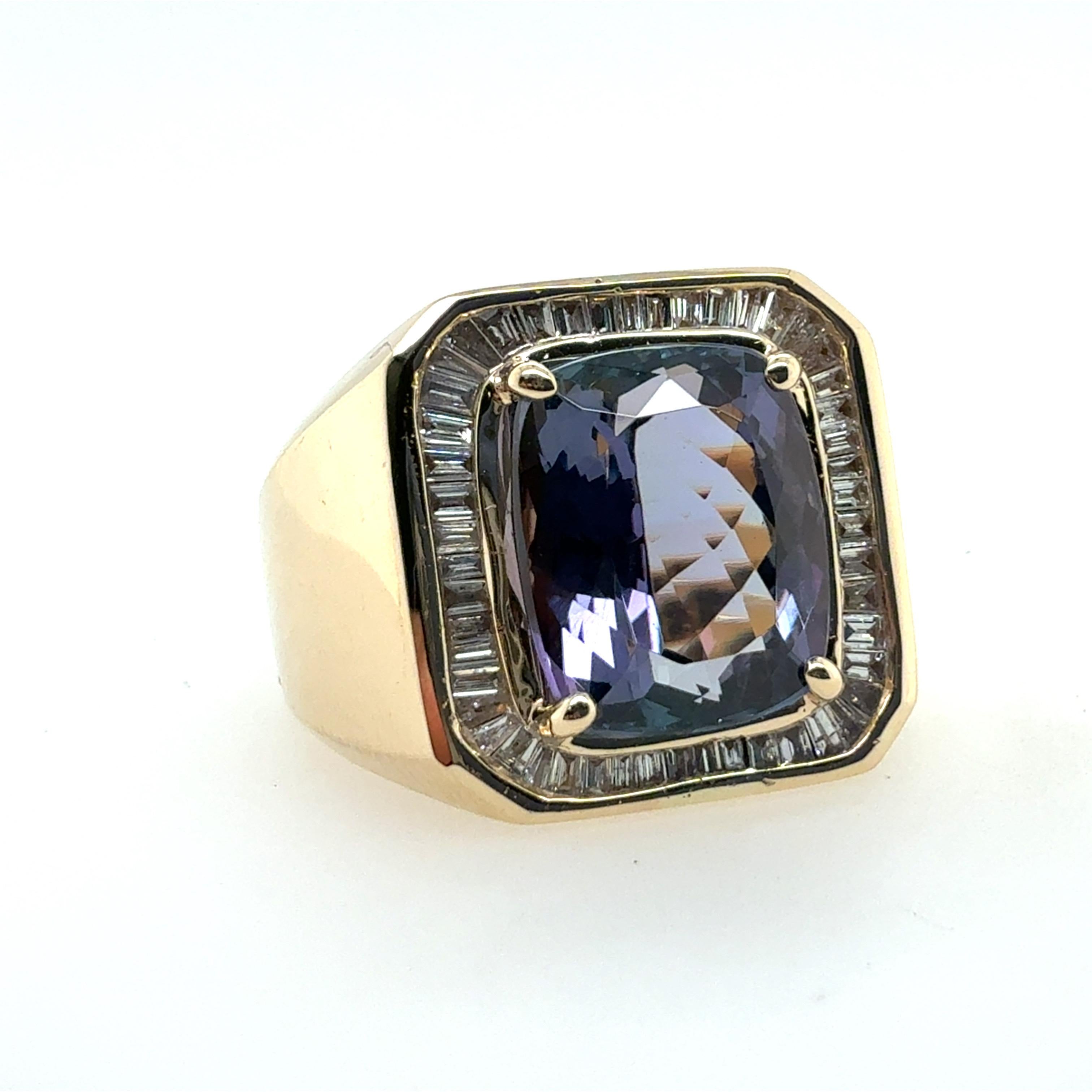Dieser auffällige Retro-Ring für Herren/Unisex ist aus massivem 14-karätigem Gelbgold gefertigt und zeigt einen lebhaften natürlichen Tansanit, der von einem kühnen Halo aus 50 natürlichen Diamanten im Baguetteschliff eingerahmt wird. Der Tansanit