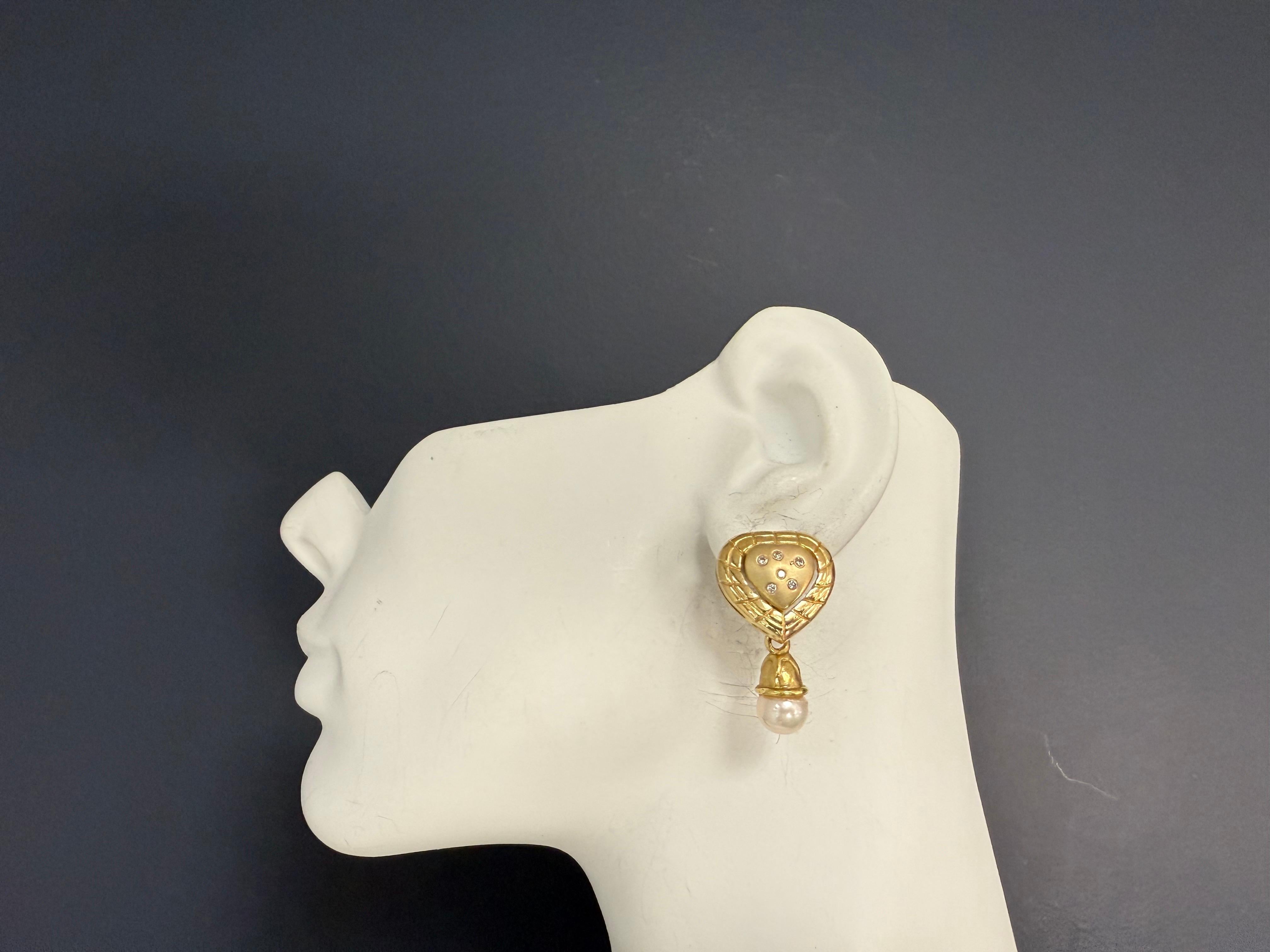 Orecchini a goccia a cuore in oro giallo 14K con 12 diamanti tondi brillanti incolore per un totale di circa 0,25 carati. Ogni orecchino è caratterizzato da una perla coltivata lucente di circa 8,3 mm di diametro. Gli orecchini misurano circa 1,25