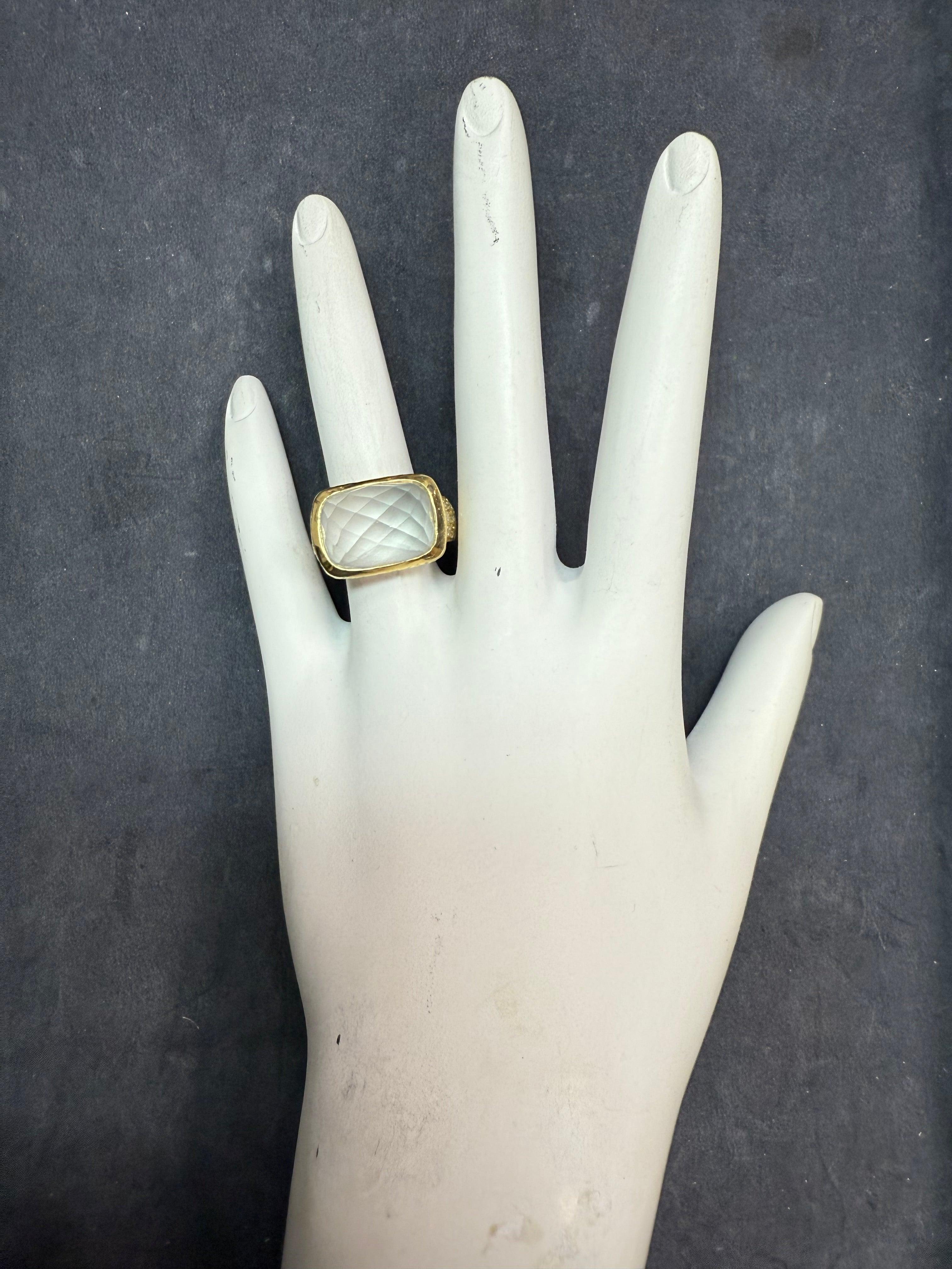 Retro 18K yellow gold cocktail ring featuring a rose cut natural rock crystal quartz measuring approximately 15 x 11 mm, accented by 12 natural colorless diamonds totaling approximately 0.15 carats. 
The ring measures 12.8 mm at the top, tapering to