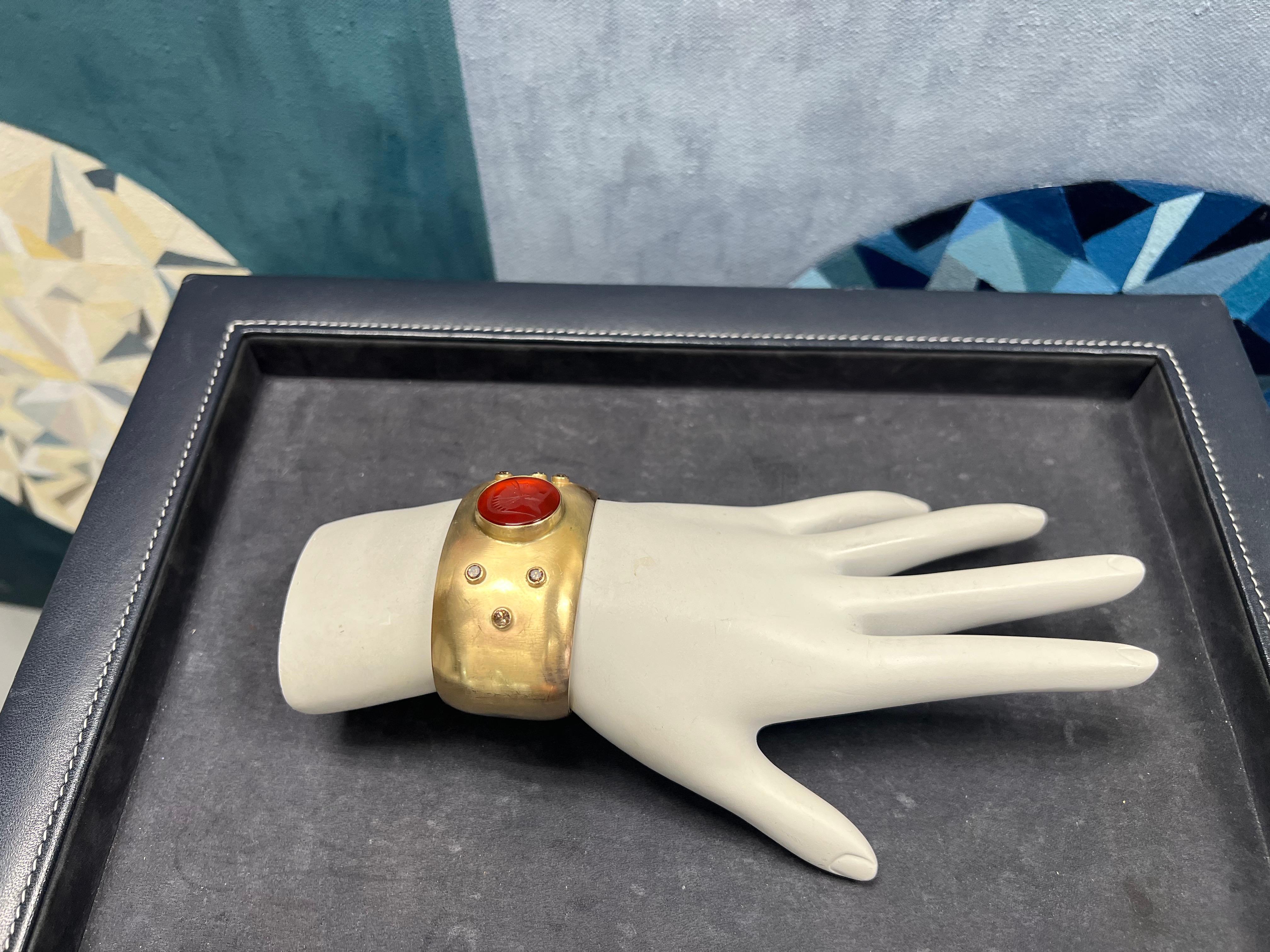 Un magnifique bracelet en or 14k euro. L'alliage a une légère teinte d'or rose, le diamètre de l'intaille en cornaline (d'un centurion romain) est d'environ 18 mm.

La pièce est sertie de 6 diamants ronds naturels de couleur brune 