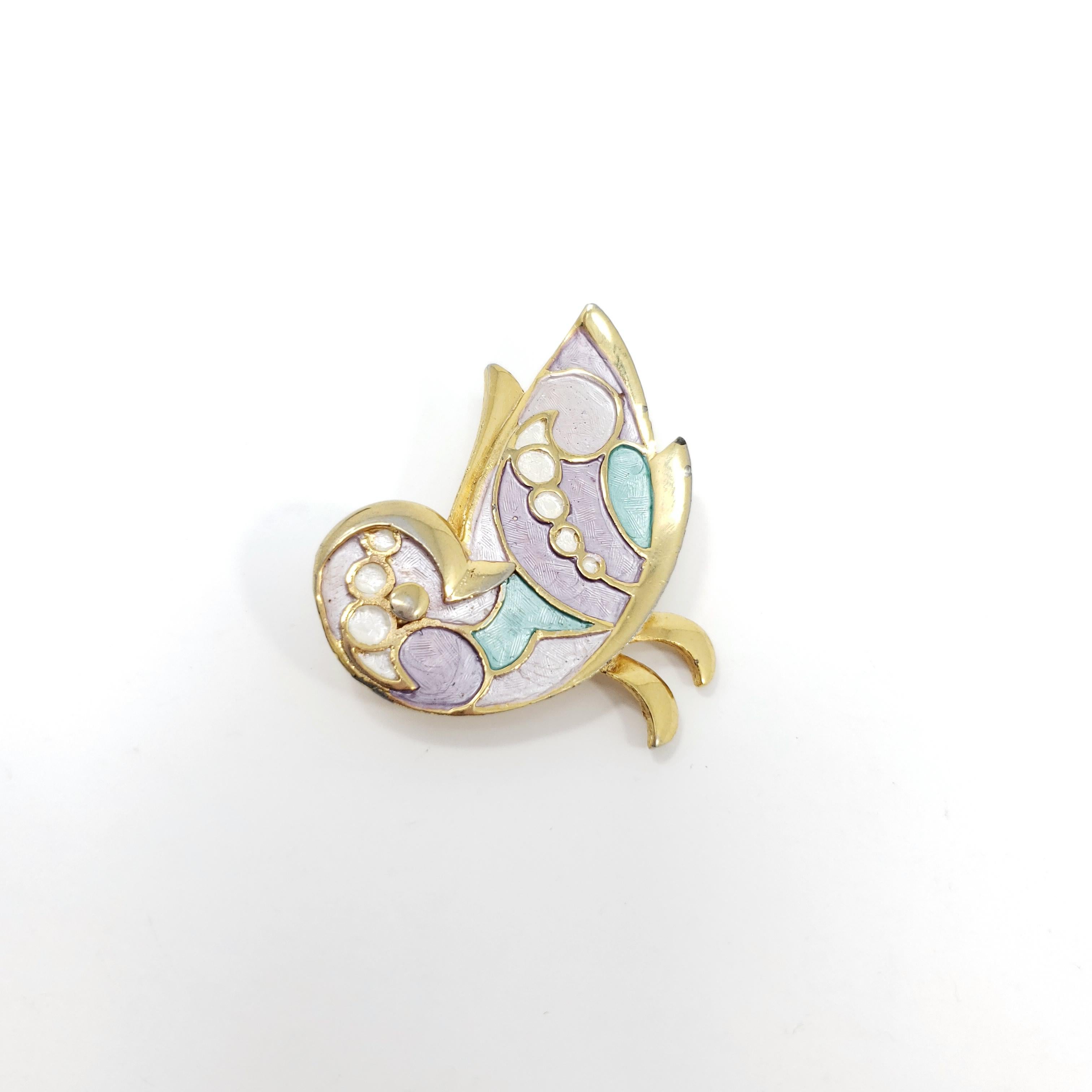 A stylish golden bird! This elegant accessory features textured enamel inlays in lilac, teal, and white.

Gold-filled.