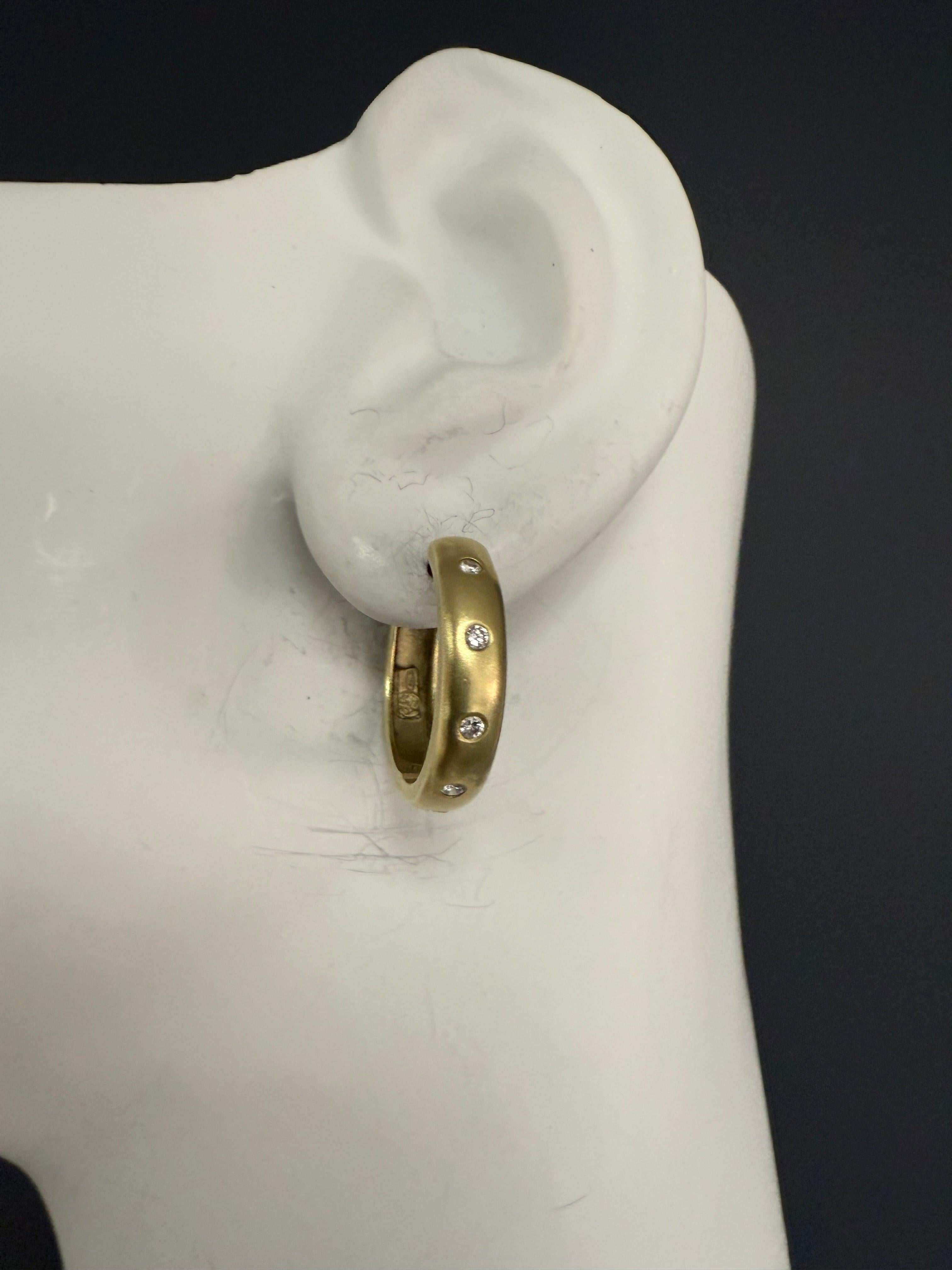 Retro-Ohrringe aus satiniertem 18-karätigem Gold, besetzt mit 10 natürlichen farblosen runden Brillanten von insgesamt ca. 0,25 Karat. Jeder Ring hat einen Durchmesser von 20 mm und eine Breite von 4,5 mm und wiegt insgesamt 6,6 Gramm.
Drei