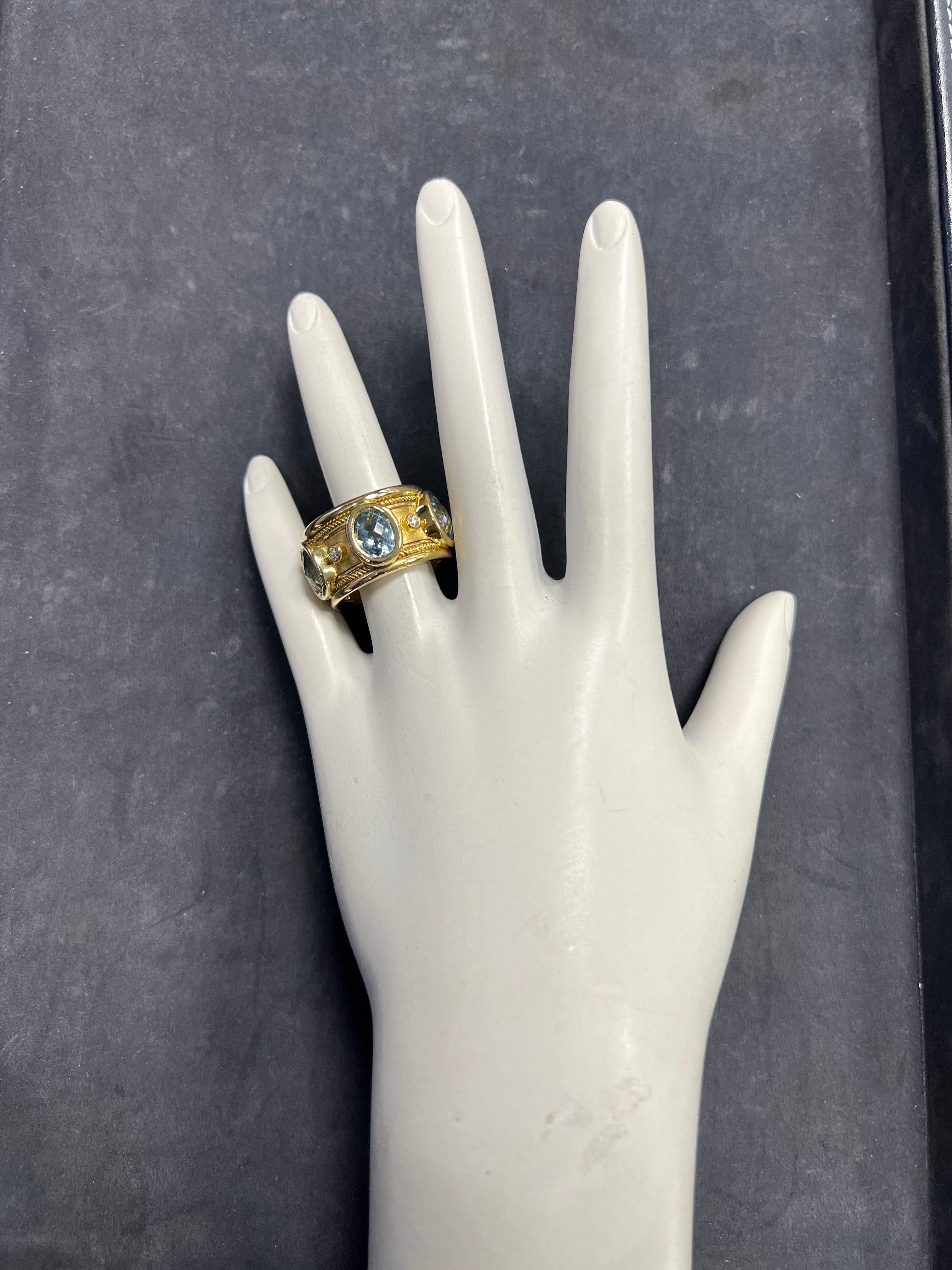 A magnificent 18k yellow gold cocktail ring signed by Christoff with a unique twisted rope design. The finish is satin in the middle and high polish elsewhere. 

Set with five swiss blue topaz ovals measuring 8x6mm and five natural colorless round