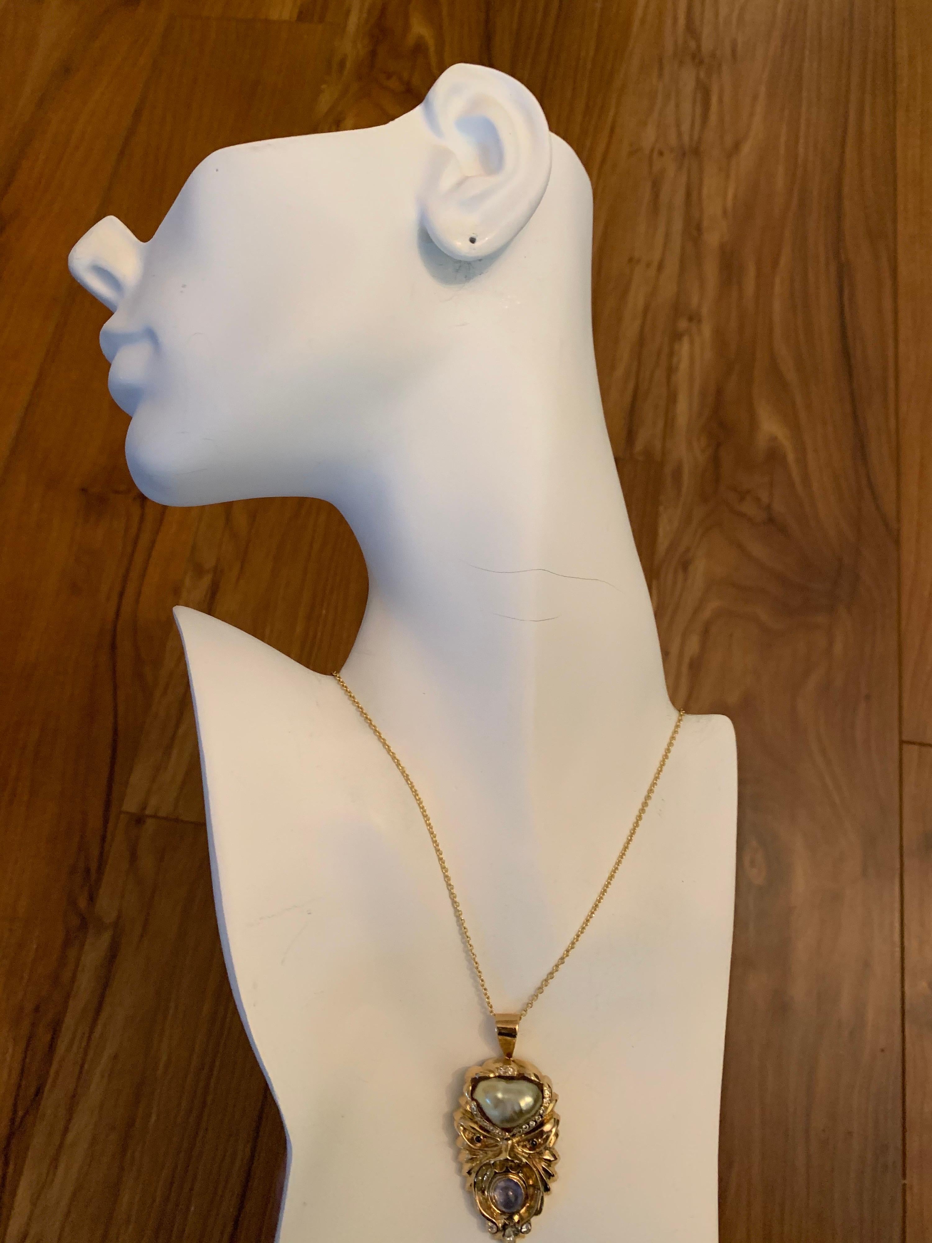 Retro 14k Yellow Gold Warrior Head Natural Pearl, Diamond & Sapphire Pendant. 

The pearl is approximately 17x12mm, the blue sapphire cabochon is 8.5mm. It includes 17 natural round brilliant and 1 marquise shaped diamond weighing approximately 0.30