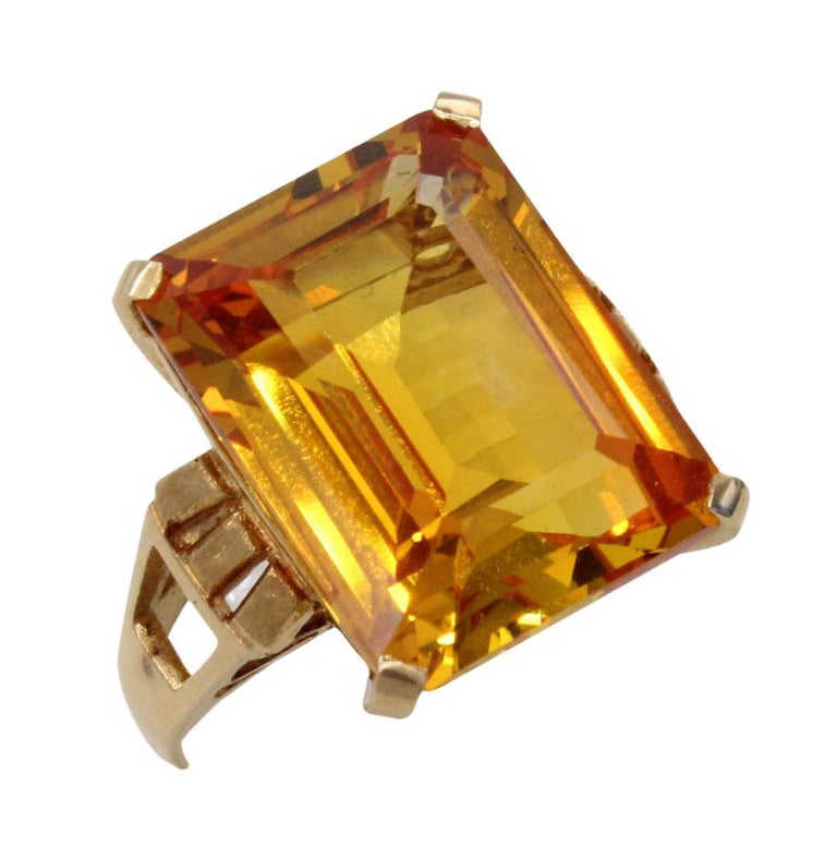 Beautifully designed and masterfully handcrafted this 18 karat gold Retro ring from ca 1945 features a Golden Citrine measured to weigh approximately 7.40 carats. The perfectly cut emerald-cut gives this gemstone its amazing color saturation, life