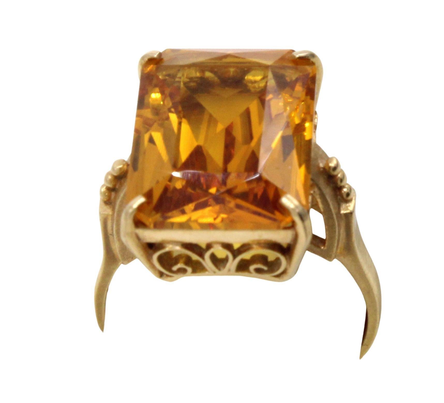 Beautifully designed and masterfully handcrafted in 18 karat yellow gold, this Retro ring from ca 1945 features a vibrant Golden Citrine measured to weigh approximately 8.60 carats. The rectangular modified emerald cut, with additional facets on the