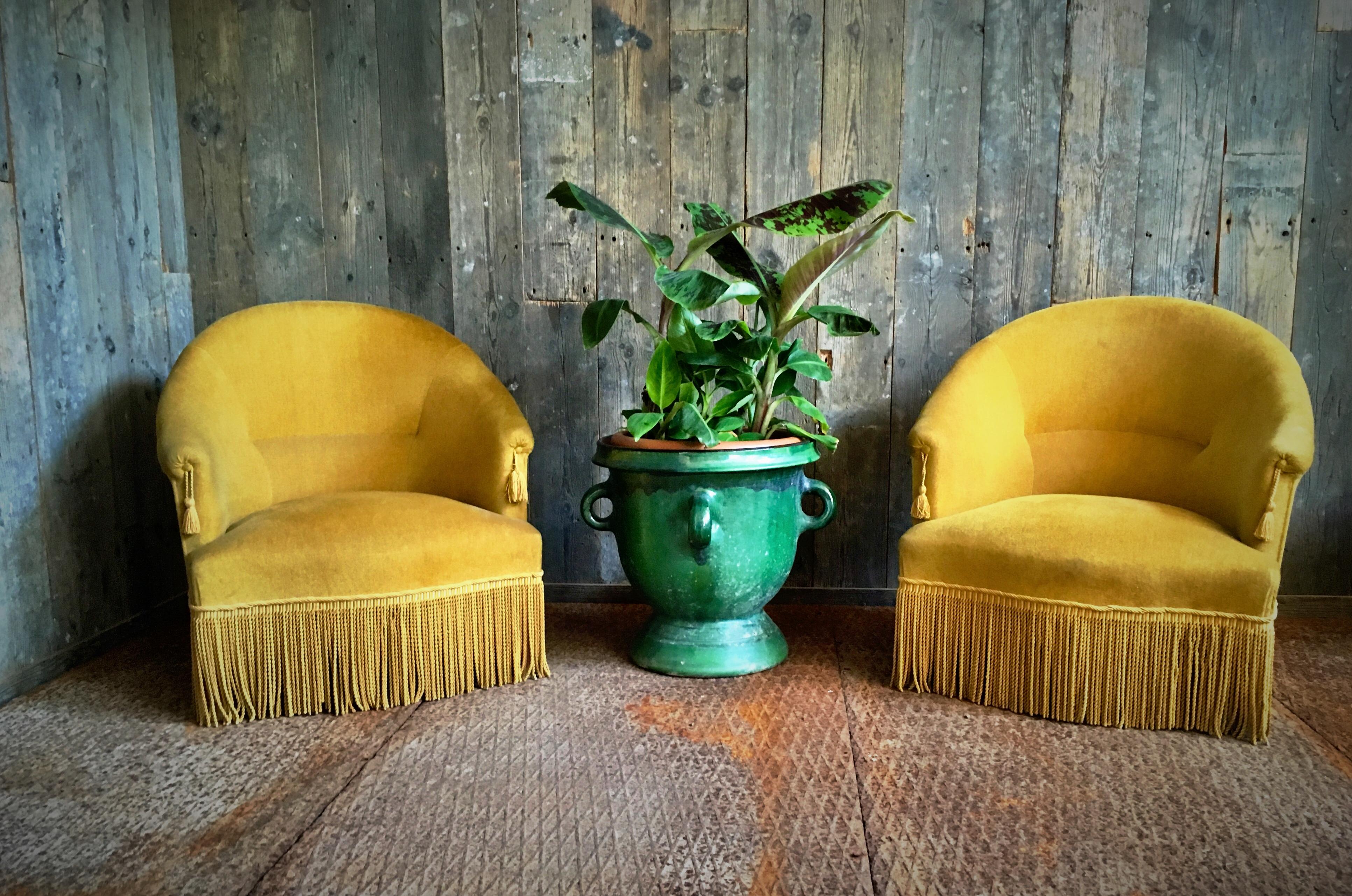 Velvet 1960s armchairs. With nice details such as fringes and a decorative tassel on the armrests. The chairs are in good condition. Measures: 68 cm wide, 63 cm deep, 67 cm high and a seat height of 32 cm.