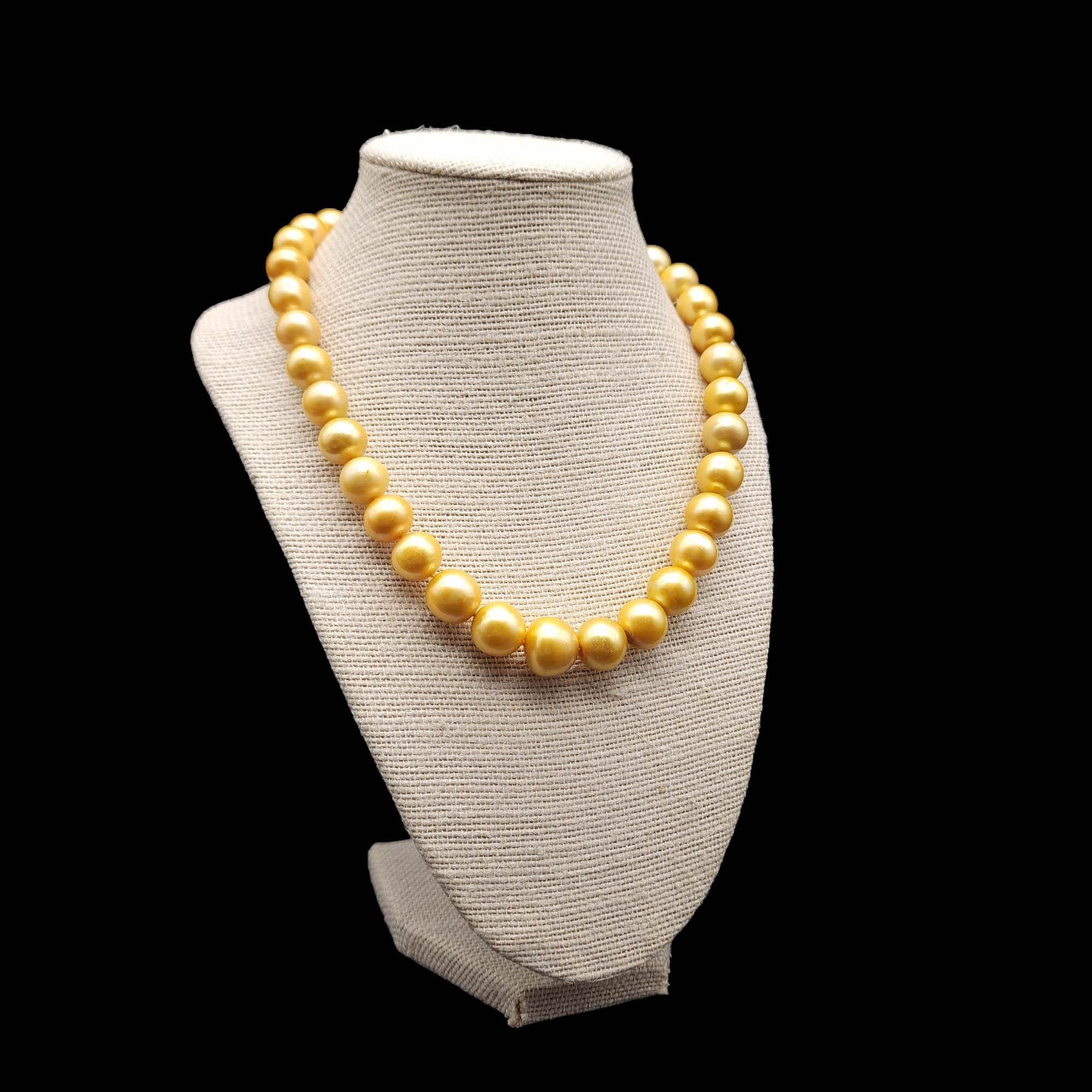 Länge der Halskette: 46cm / 17.75 inches
Zuchtperle, von 1 cm bis 1,5 cm
Marken / Punzierungen: 925 (Schließe)

Schwelgen Sie in der Opulenz unserer goldenen Perlenkette, einer Symphonie aus Glanz und Eleganz. Jede einzelne goldene Perle wird