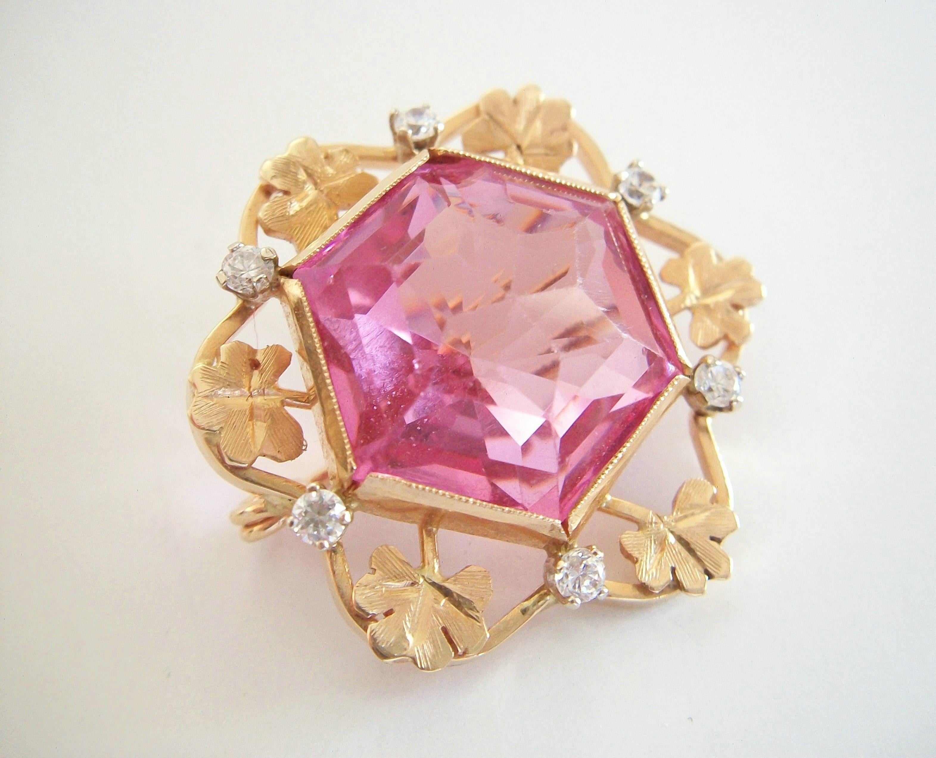 Retro 14K yellow gold custom made brooch - set with one hexagonal cut pink crystal (approx. 24 carats - 20 mm. x 17 mm. x 13 mm. deep) - surrounded by gold chased sprigs of clover and six claw set clear crystals (approx. 1/3 carat total - 2 mm.