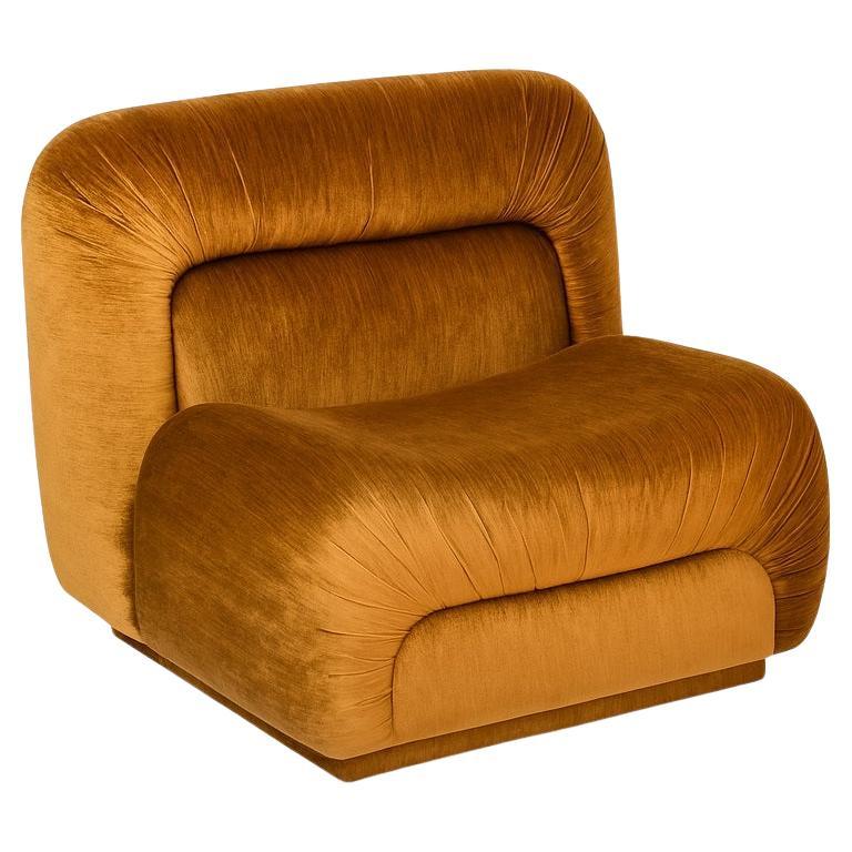 Ce fauteuil présente un jeu distinctif de textures et de couleurs grâce à sa forme curviligne caractéristique. Les détails plissés accentuent les formes douces et arrondies de l'assise et du dossier bas, ajoutant à son caractère expressif. Parfait