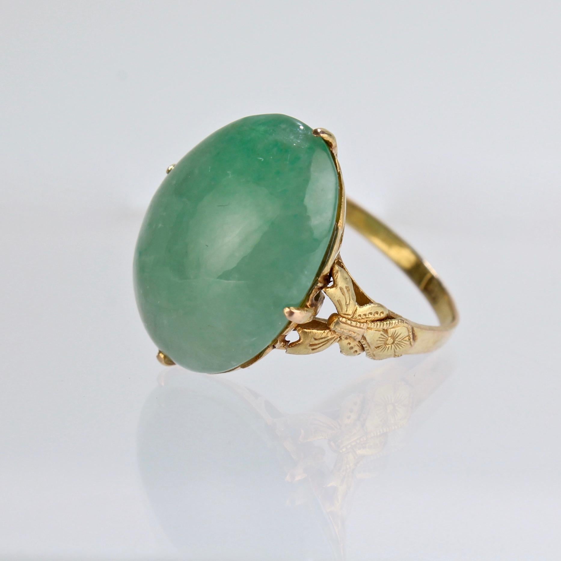 A fine estate 14k gold and jade ring.

Dating to the 1970s, the jadeite cabochon is prong set in a textured 14k gold setting. The The shoulders have a finely-worked butterfly and flower design and the basket setting has openwork to allow light to