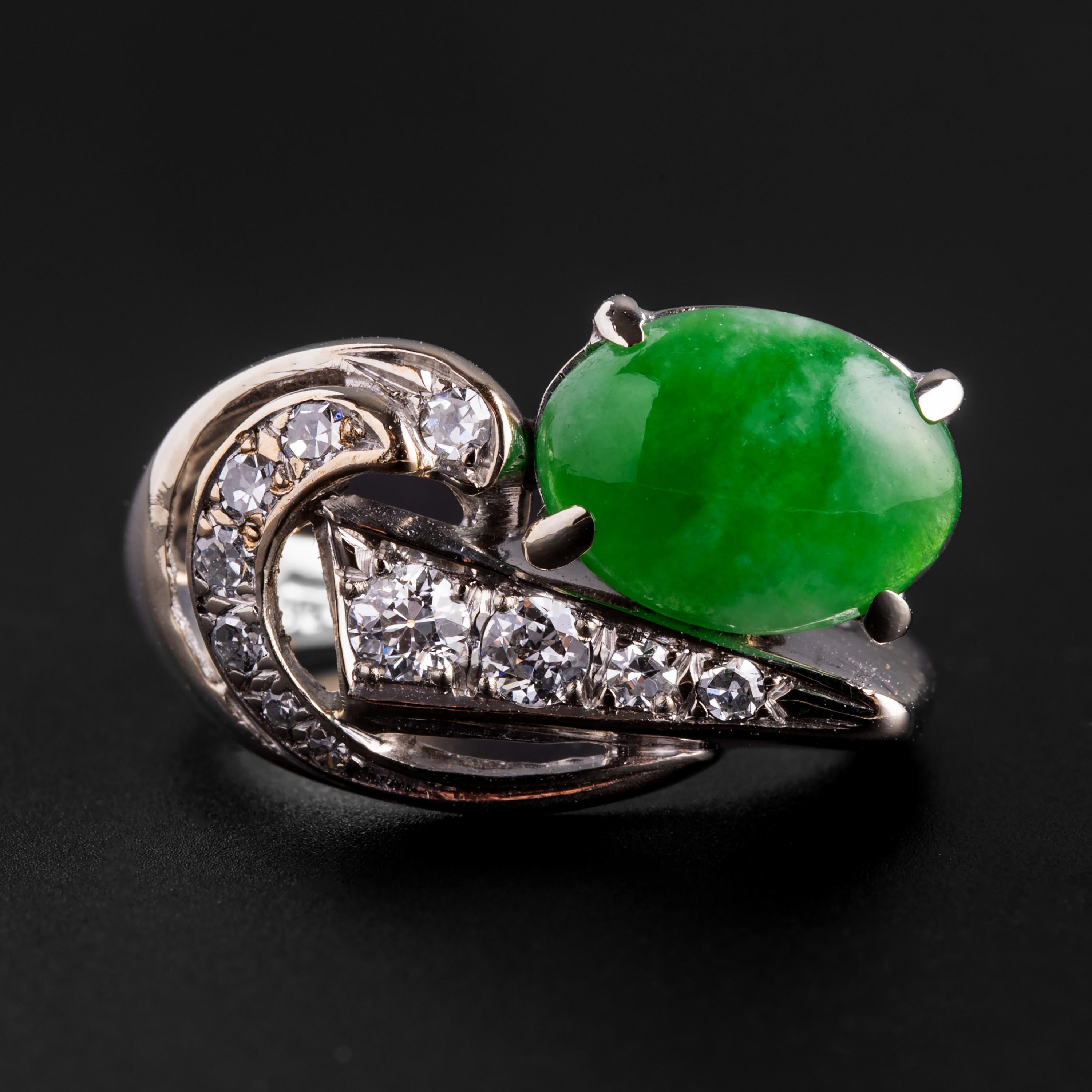 This Retro era certified untreated jadeite jade and diamond ring is whimsical, sculptural, stylish, and fun. Not to mention glamorous. Crafted in 14K white gold, the star of the show is a highly translucent 9.92 mm x 7.5 mm cabochon of a juicy,