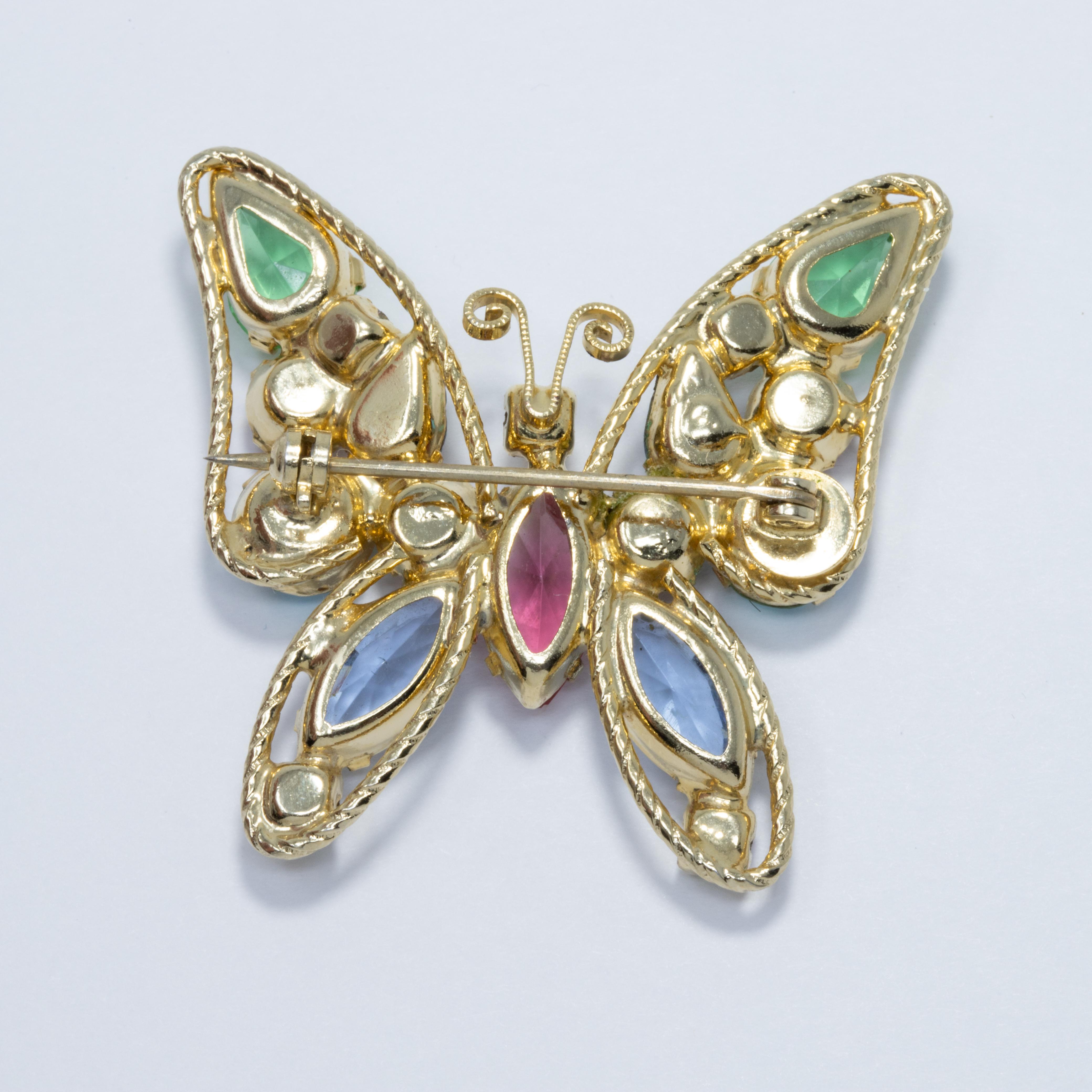 This gorgeous golden butterfly brooch is decorated with dazzling aquamarine, amethyst, topaz, emerald, and aurora borealis crystals.

All gems are prong-set, and some are open-back.

Circa mid-late 1900s. Gold plated. Designer unknown.
