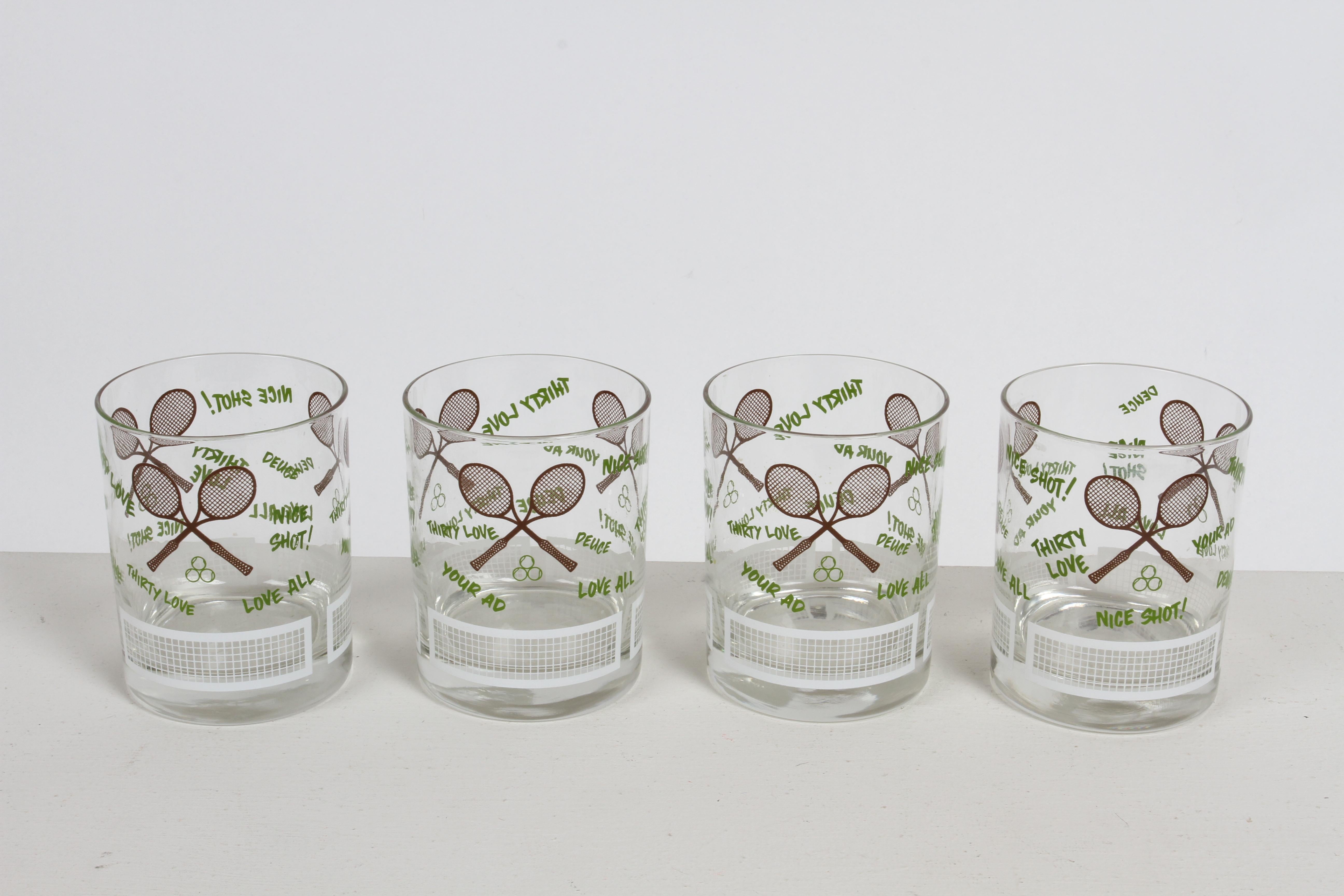 Vintage 1970s set of 4 Tennis theme barware rocks glasses.  Printed in white, green and brown Ink, with 3 sets of crossed rackets, words like Love All, Nice Shot !, Thirty Love, Deuce, Your Ad and white tennis nets around the bottom. Unmarked. 