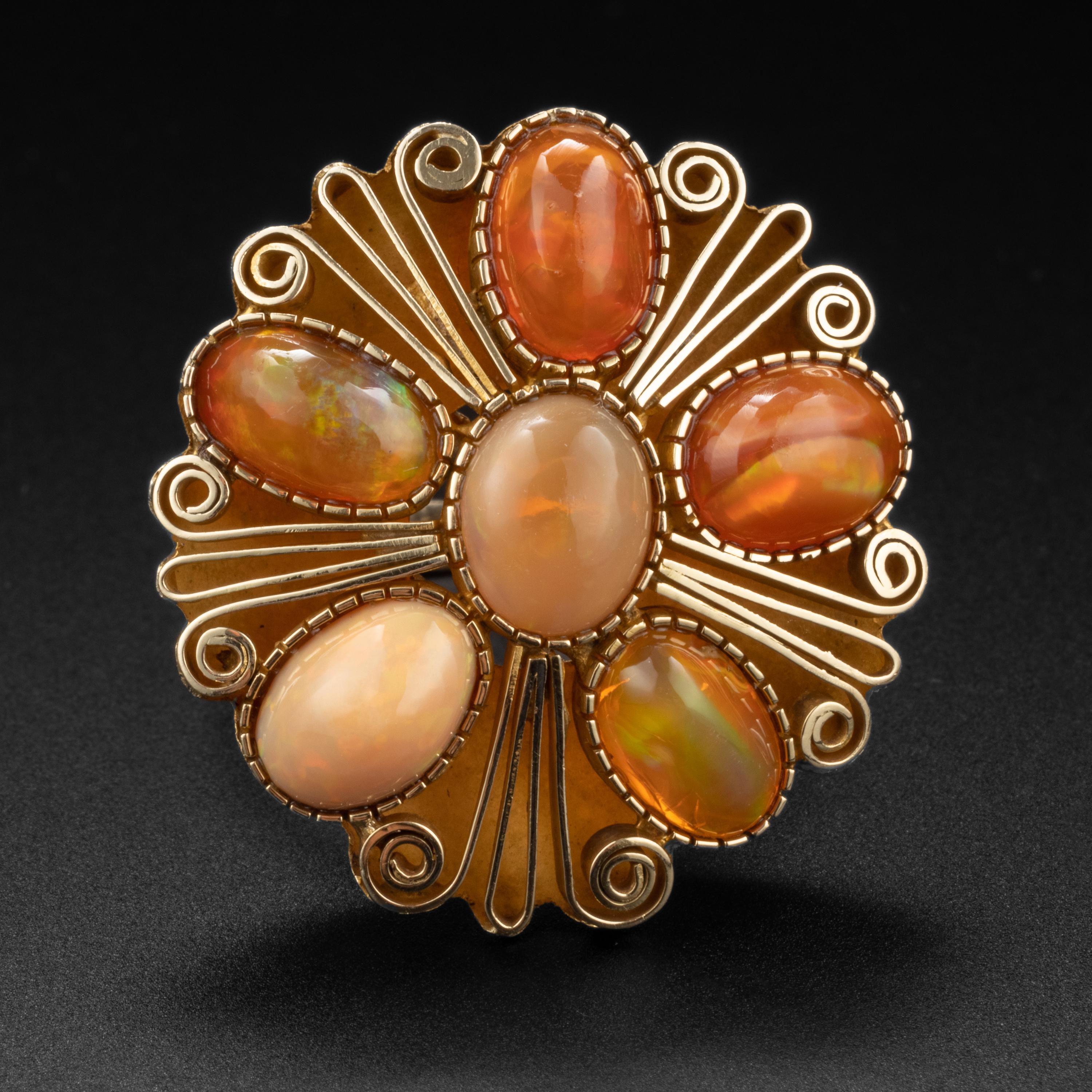 A spectacular and utterly unique 14K yellow gold ring from the Retro era (circa 1940s) featuring six cabochons of natural fire opals from Mexico. These gorgeous and highly-prized gems measure from 9.2mm x 6.7mm to 8.8mm x 6mm. They display orange,