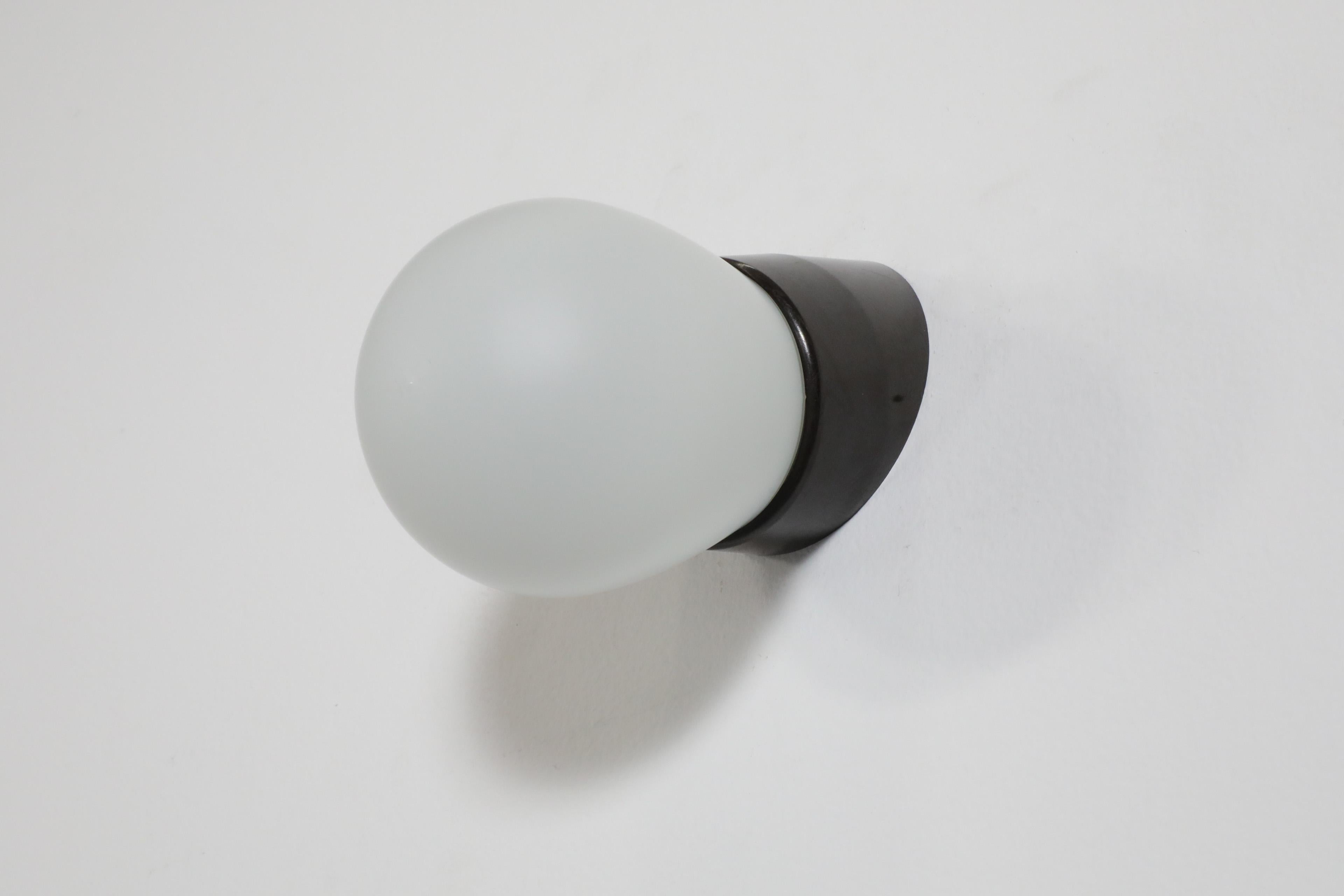 Milk Glass Retro Mid-Century Frosted Bulbous Glass Sconce with Angled Black Bakelite Base For Sale