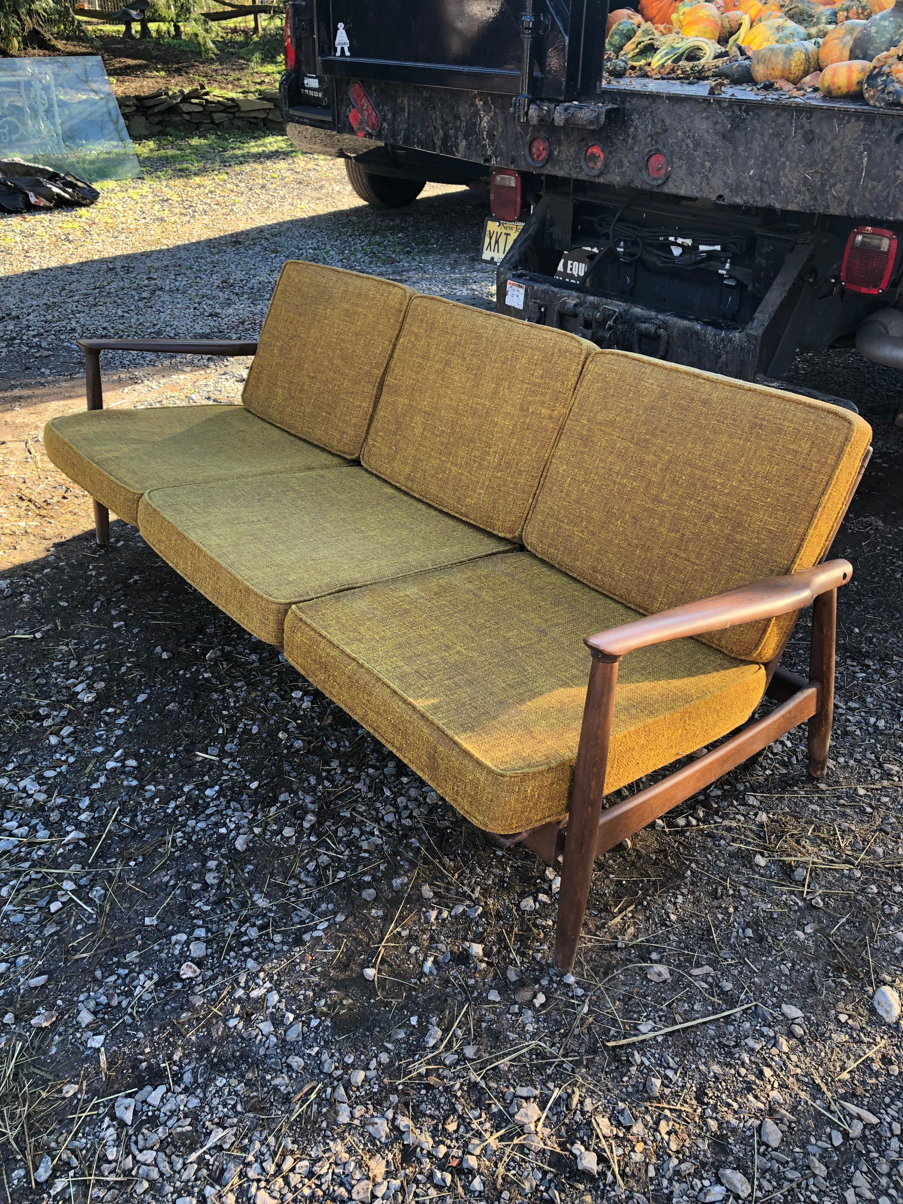 Sleek mid century modern wooden sofa with great bones that looks like it's right off the set of Mad Men.  Recommend seat cushions be used as templates for replacement cushions.  
seat height without cushion 12