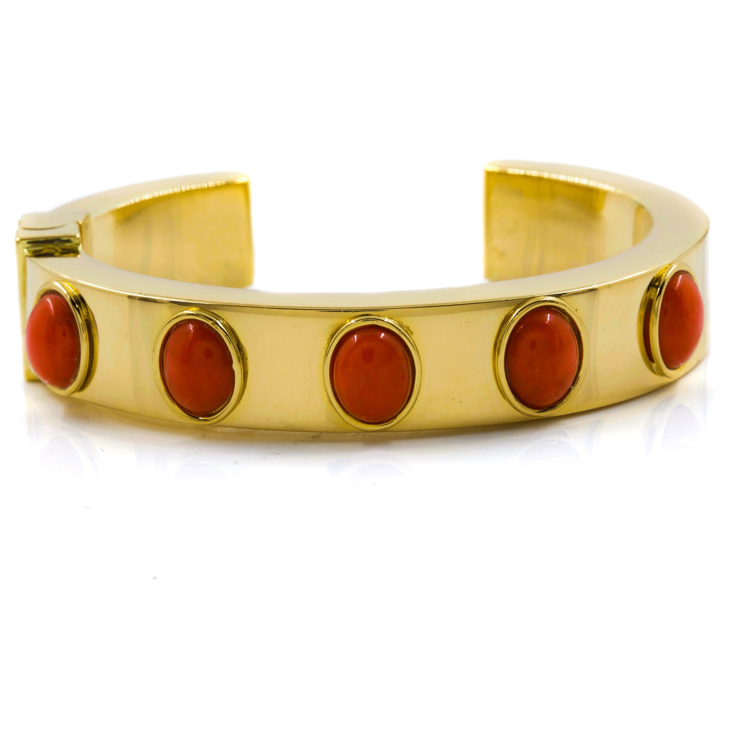This incredibly fine and unusually heavy hinged cuff bracelet is carefully crafted entirely of 18k yellow gold, the top set with five red high-polish cabochon stones within raised rims. The surface is high-polish and austere, the end of the cuff