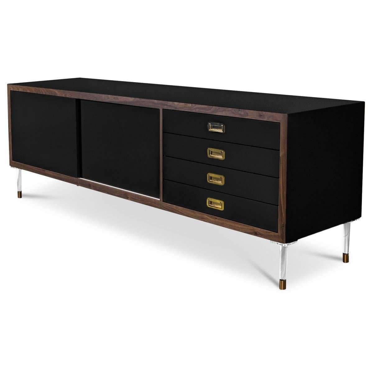 Introducing our new St. Martin Credenza featuring two sliding doors and four drawers to maximize its functionality while still being stylish and chic. This retro-modern design features an oiled walnut trim, brass hardware, our famous Black lacquer