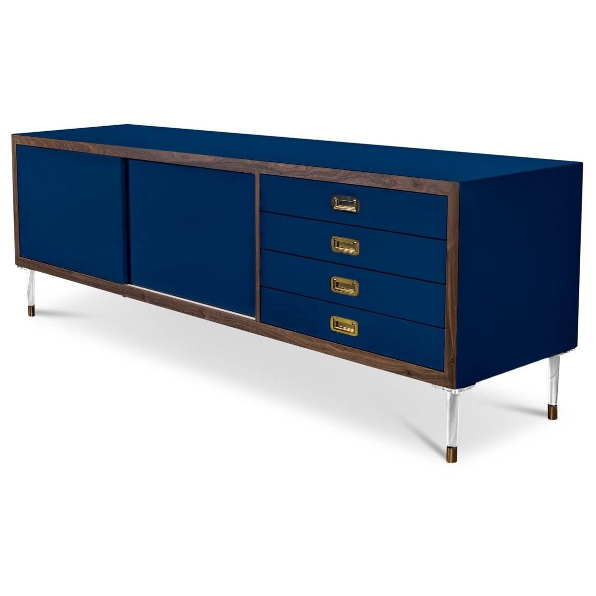 Introducing our new St. Martin credenza featuring two sliding doors and four drawers to maximize its functionality while still being stylish and chic. This retro-modern design features an oiled walnut trim, brass hardware, our famous Navy lacquer