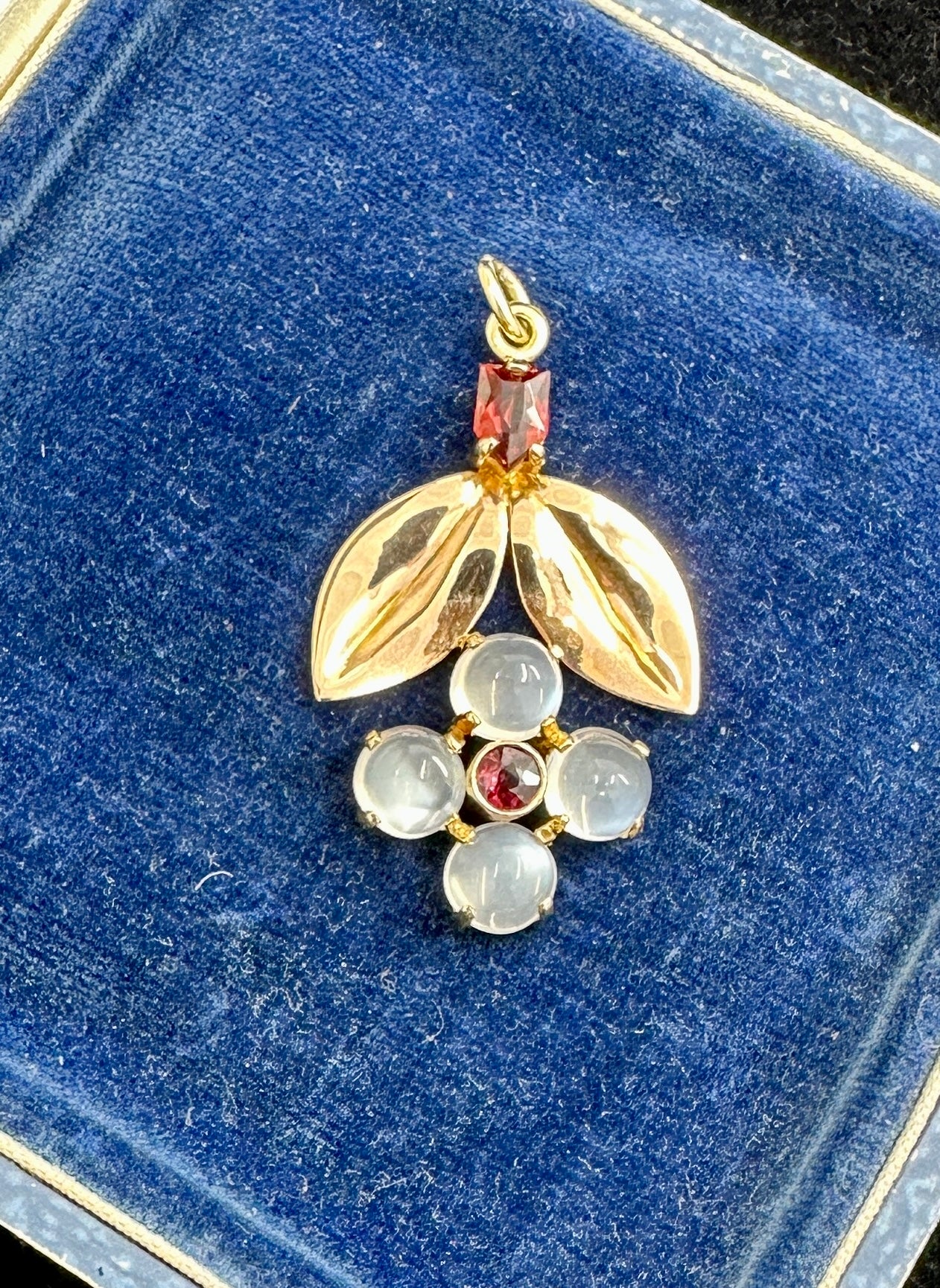 Il s'agit d'un magnifique et rare pendentif fleur en pierre de lune et grenat en or rose et jaune 14 carats.  Ce magnifique bijou est un pendentif ancien datant de la période Mid Century Jewell's.  Il est dans le style des bijoux de fleurs de