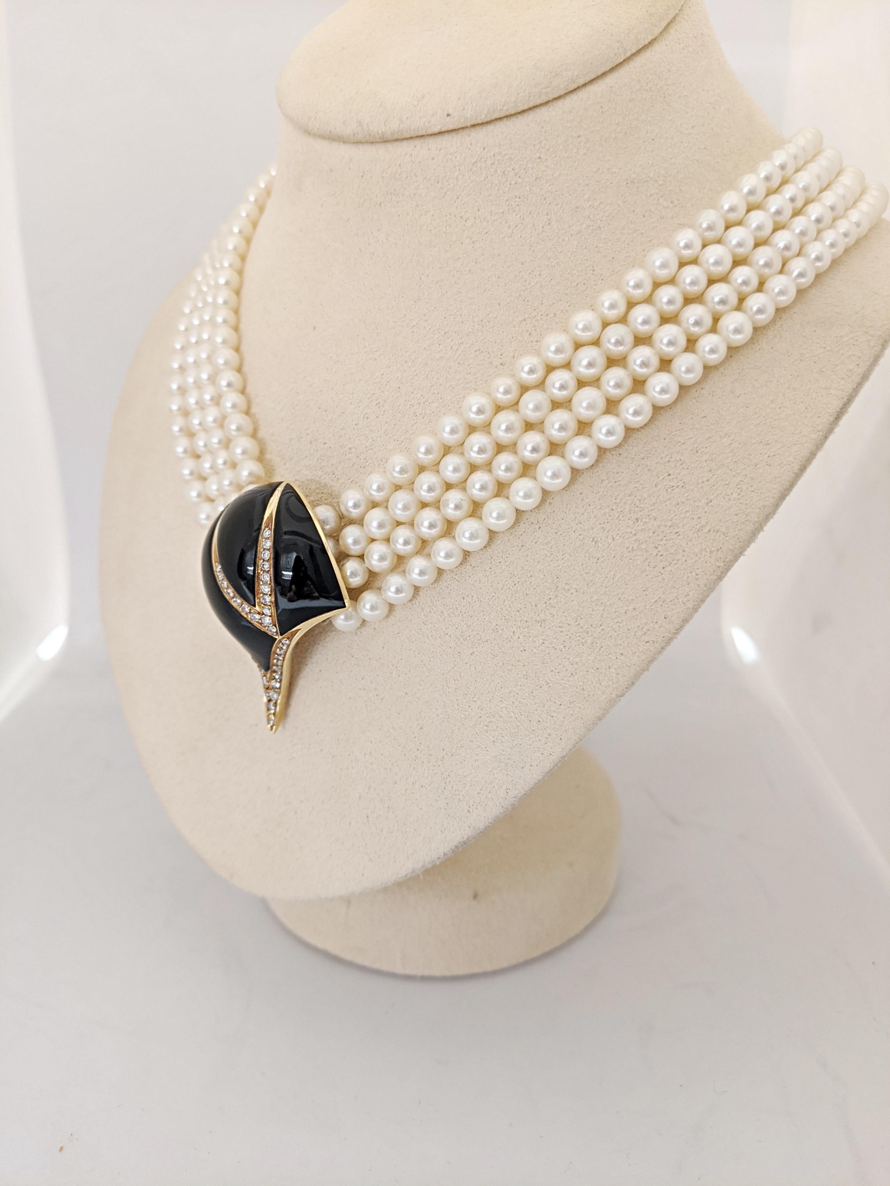 This vintage choker necklace is designed with 4 strands of 4-5 mm cultured pearls. The clasp, which closes in the front is 18 karat yellow gold set with Black Onyx and round brilliant Diamonds. The length is 16