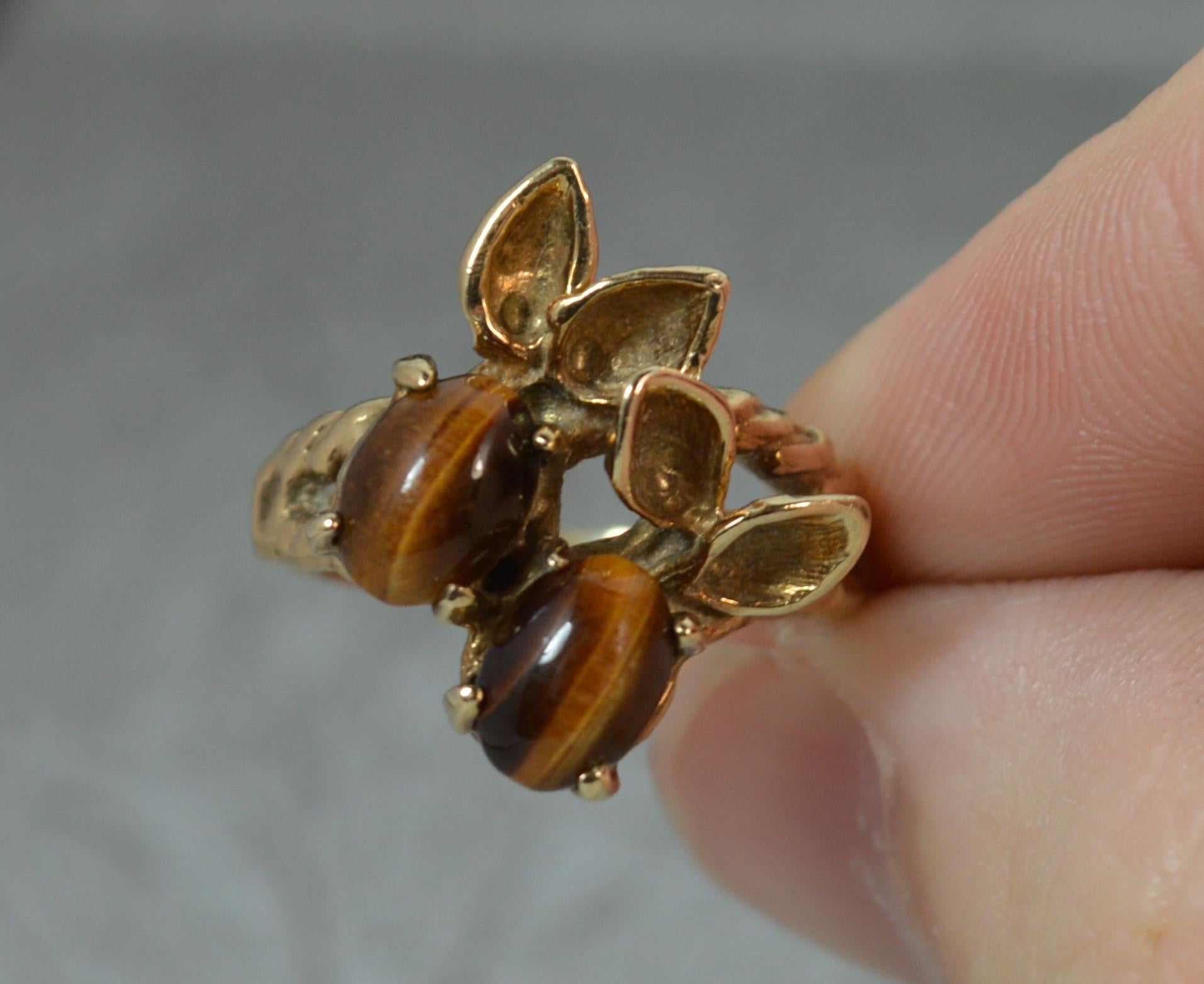 A superb 9 carat gold, tigers eye cluster ring.
​Retro example of natural berry form.
Set with two tiger's eye oval shaped stones with gold leaf design.

CONDITION ; Excellent. Well set stones, good strong claws. Strong band, light wear. Issue free.