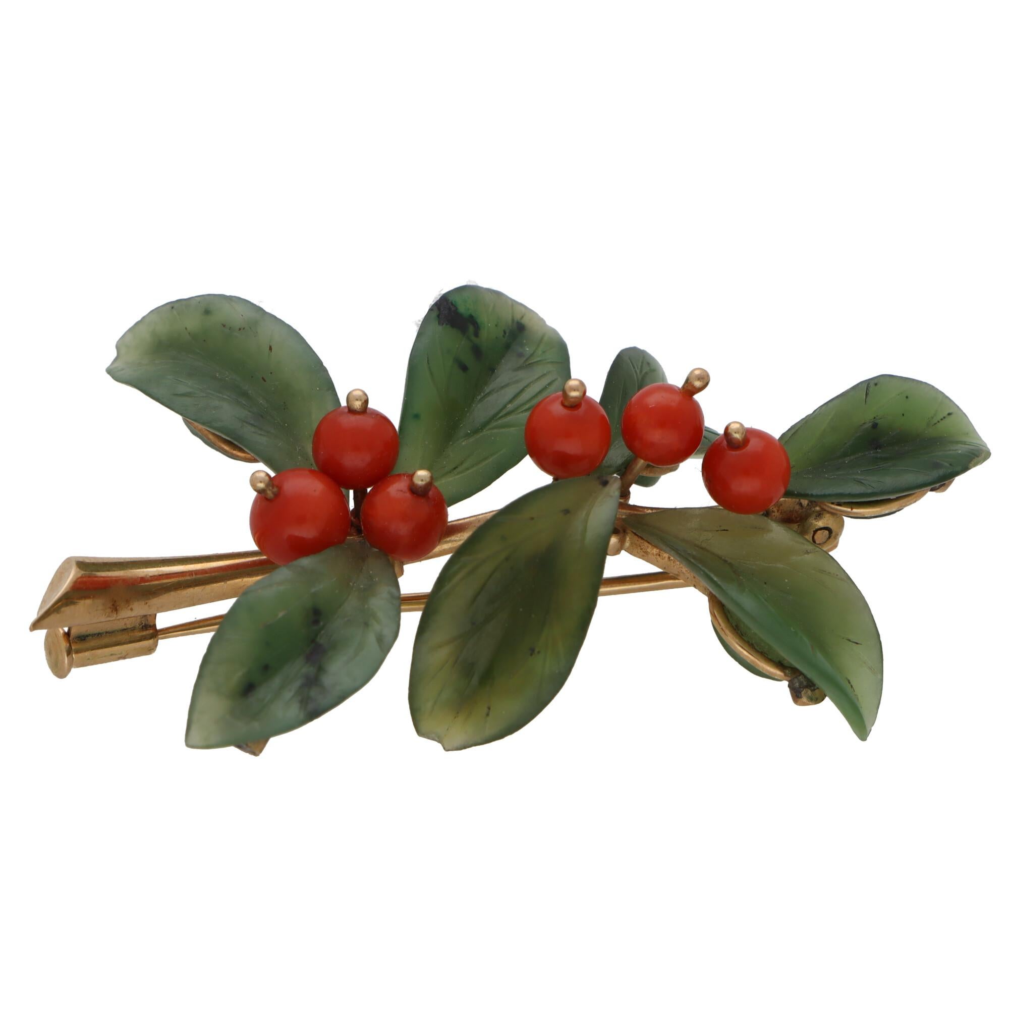 - May require a CITES upon importation. Please inquire to 1st dibs -

A highly unique nephrite and coral leaf and berries brooch set in 14k yellow gold.

This beautifully crafted piece is designed as a floral-esque spray and is predominantly set