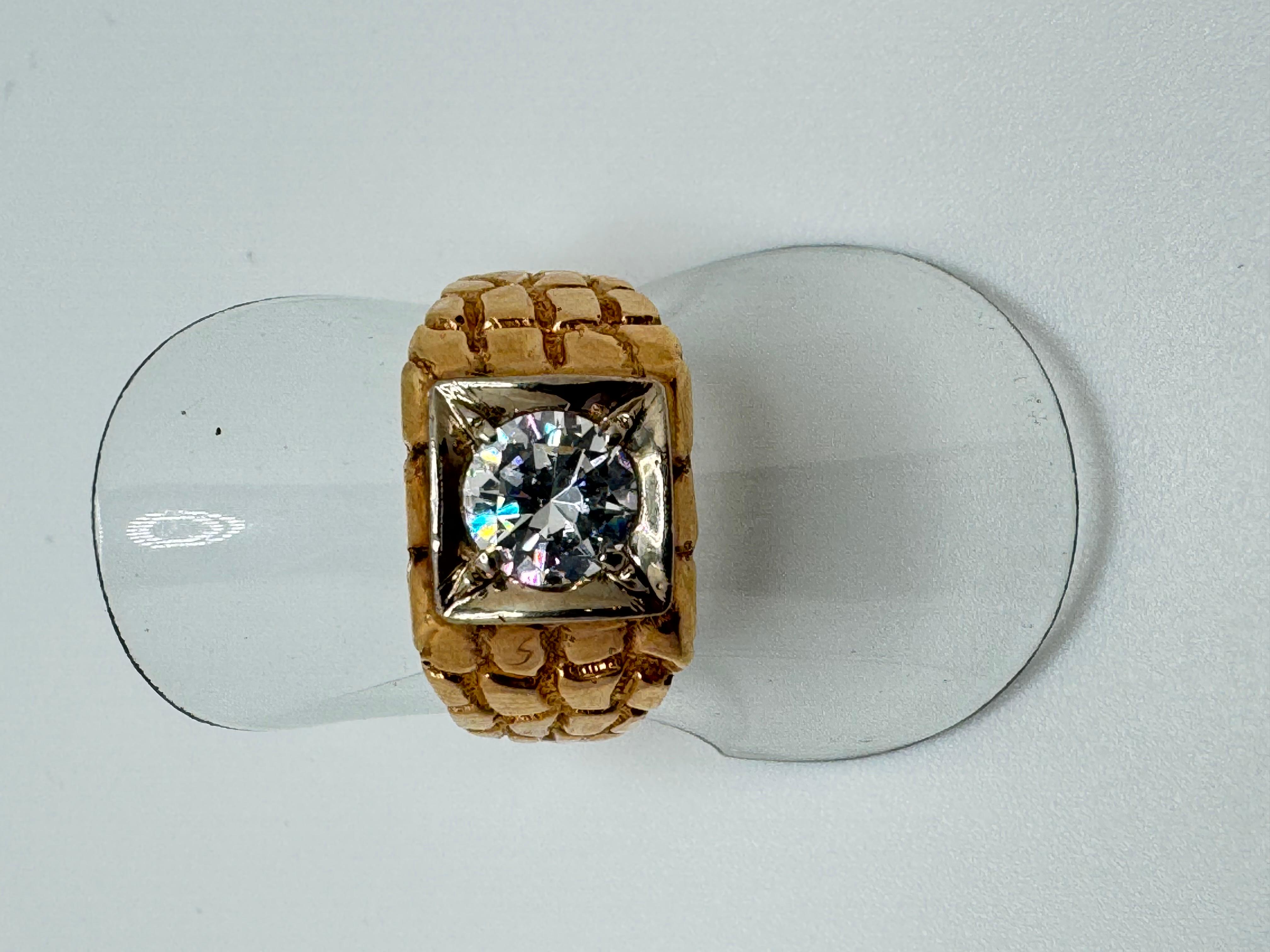 Questo accattivante anello è realizzato in oro giallo 14K e mette in mostra una brillante gemma Renzite rotonda di 7 mm, del peso di circa 1,37 carati. La pietra è incastonata in un castone basso, incorniciato da un bordo di forma quadrata che ne