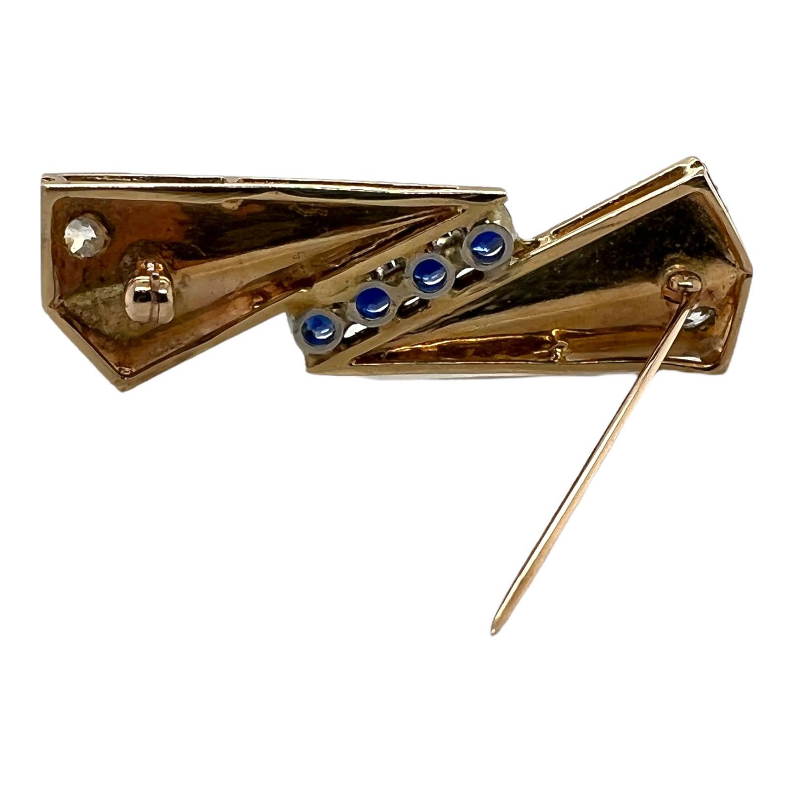 Retro diamond and sapphire brooch handcrafted in 14 karat yellow gold. The geometrical shape brooch features 2 Old European cut diamonds weighing approximately .66 carat total weight and graded H-I color and SI clarity. The 4 natural blue sapphires