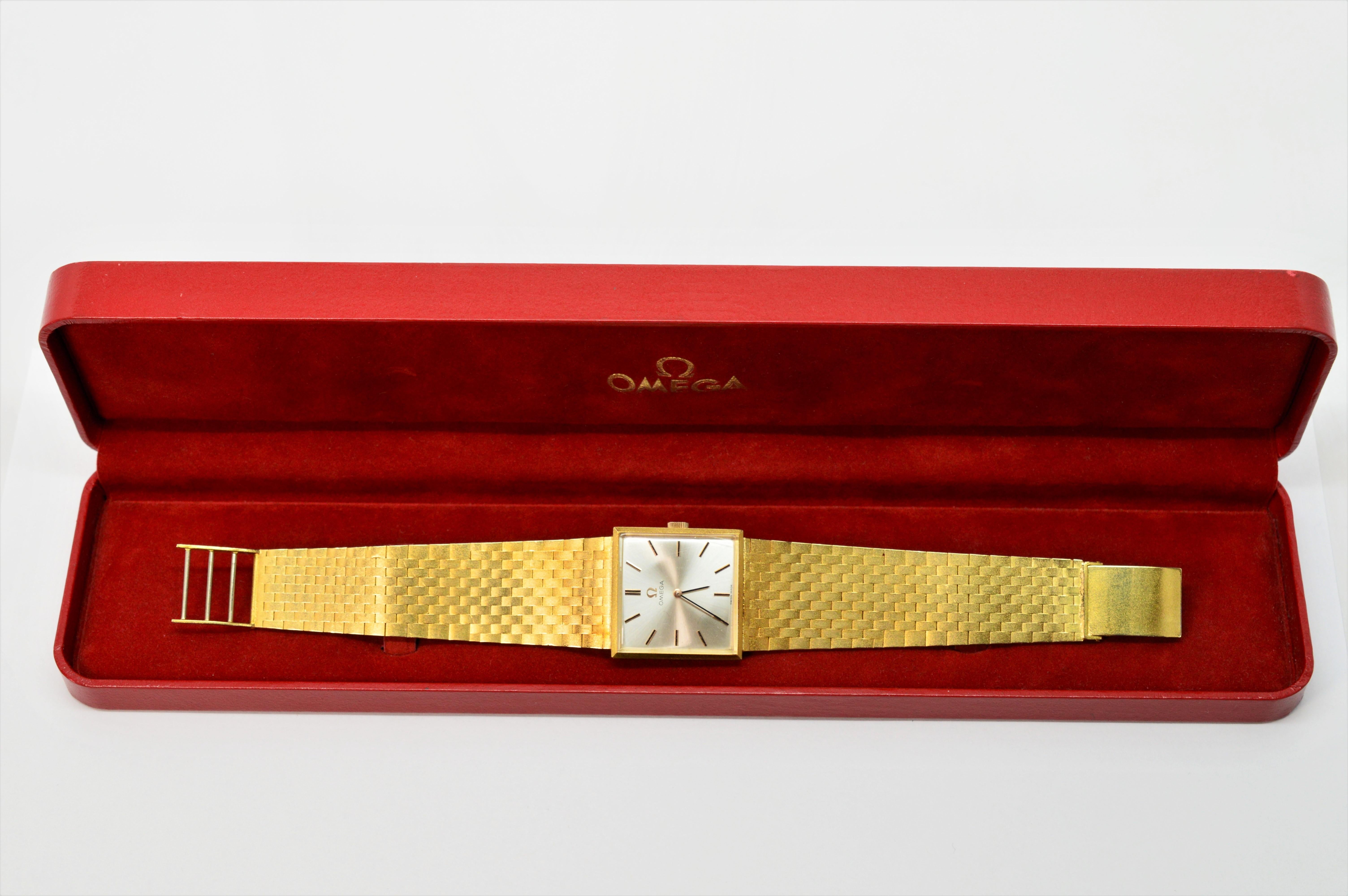 Setzen Sie mit dieser Omega 620 Armbanduhr aus 18-karätigem, satiniertem Gelbgold ein markantes Zeichen. CIRCA 1960er Jahre, dieses schlanke Design mit quadratischem Gehäuse hat ein silberfarbenes Zifferblatt und goldene Ziffernblöcke. Die Uhr
