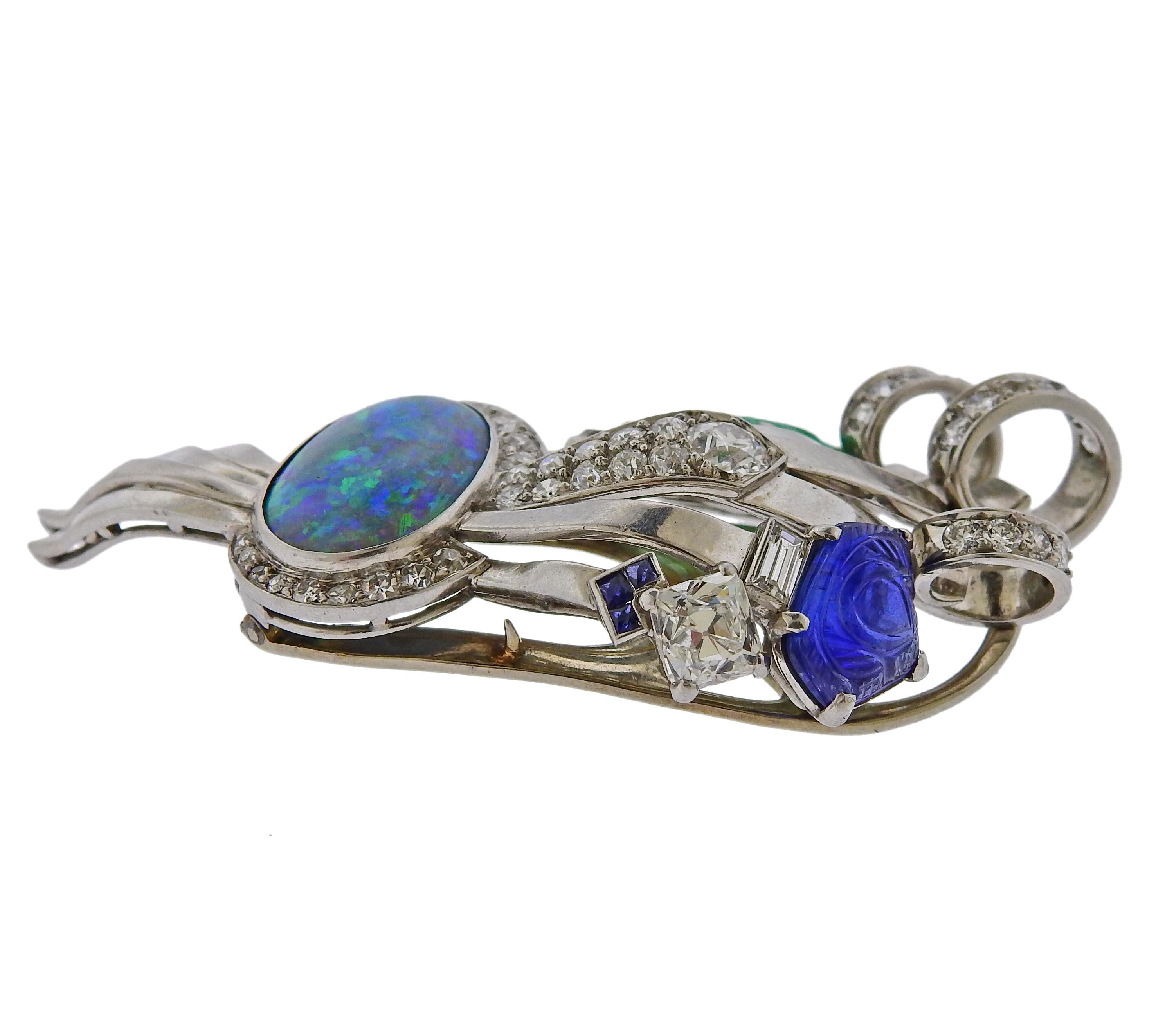 Mid century retro platinum brooch, featuring oval 14.8mm x 10.3mm opal, carved emerald, sapphire and approximately 2 carats in diamonds  (largest stone is approx. 0.85ct ). The brooch is 55mm x 30mm. Tested plat. Weighs 23.1 grams.

SKU#PB-02994