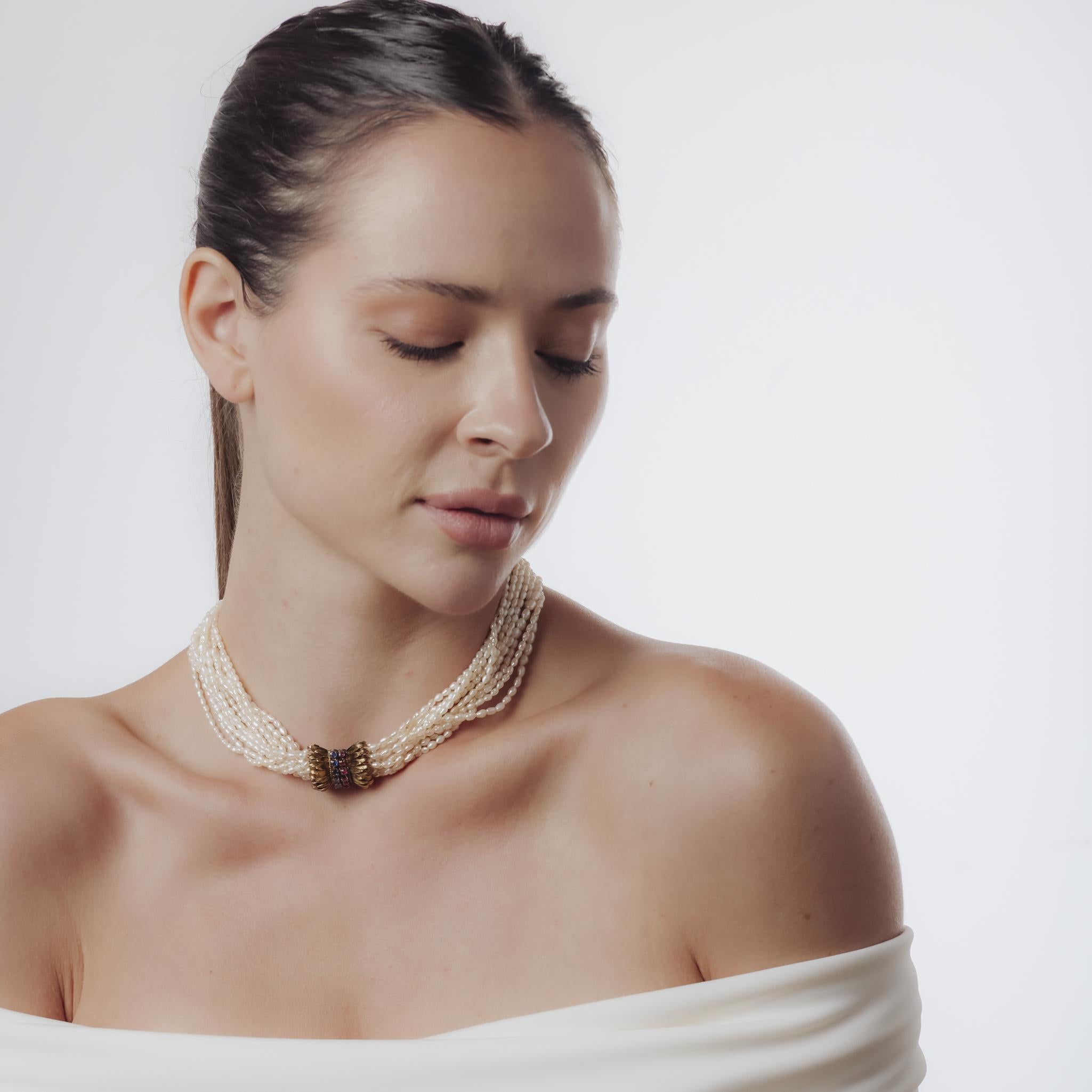 Ce collier Retro des années 1940 est composé de 12 brins de perles lumineuses mesurant environ 2,70 x 3,80 mm. Huit saphirs et huit rubis ronds, d'un poids total d'environ 1,60 carat, rehaussent le design et ajoutent un contraste vibrant à l'éclat