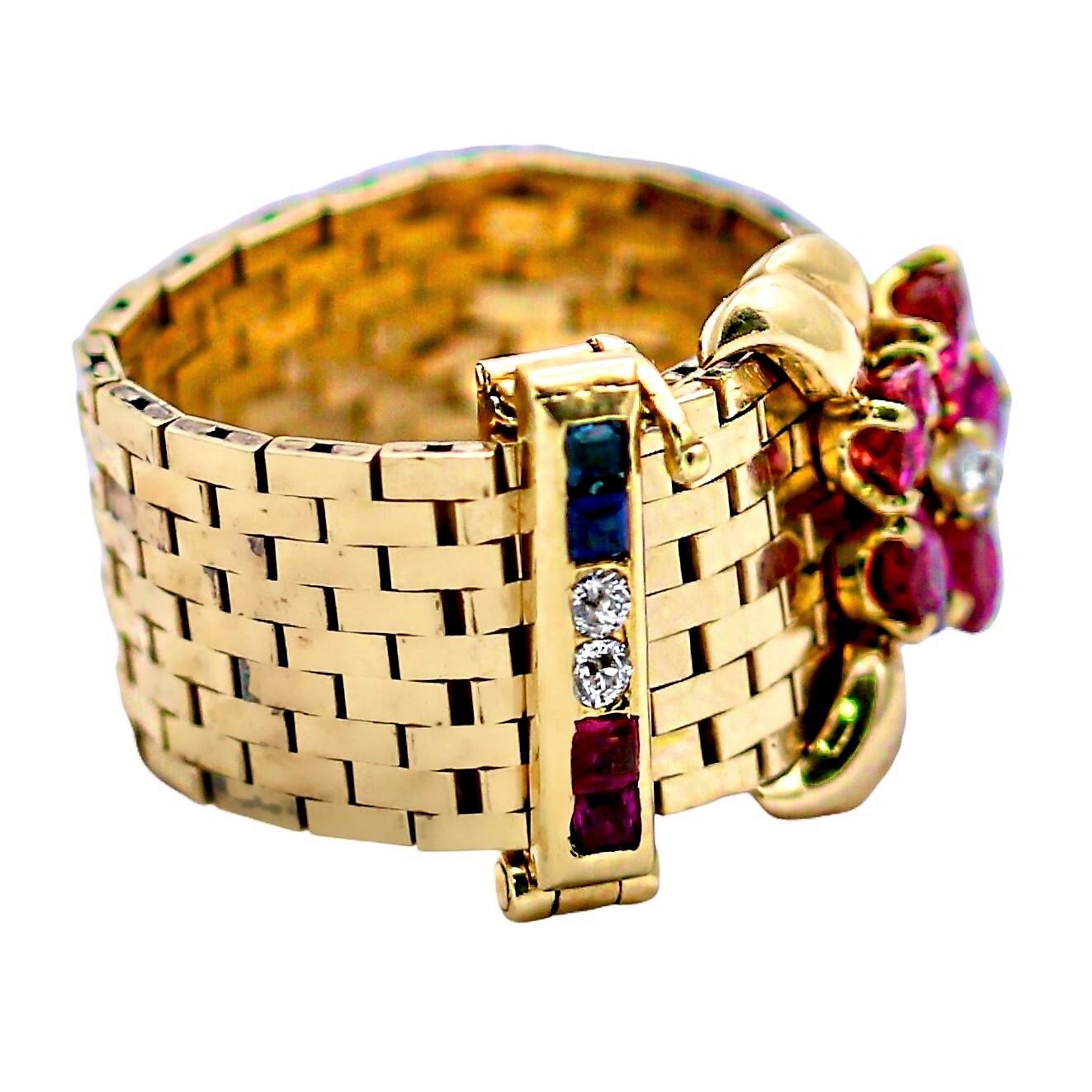This 14k yellow gold Mid-20th Century American buckle ring is a bit unique. Most terminate in a point which is typically set with precious stones but this one is adorned with a natural ruby floret at it's tip. Additionally, the flip clasp is set