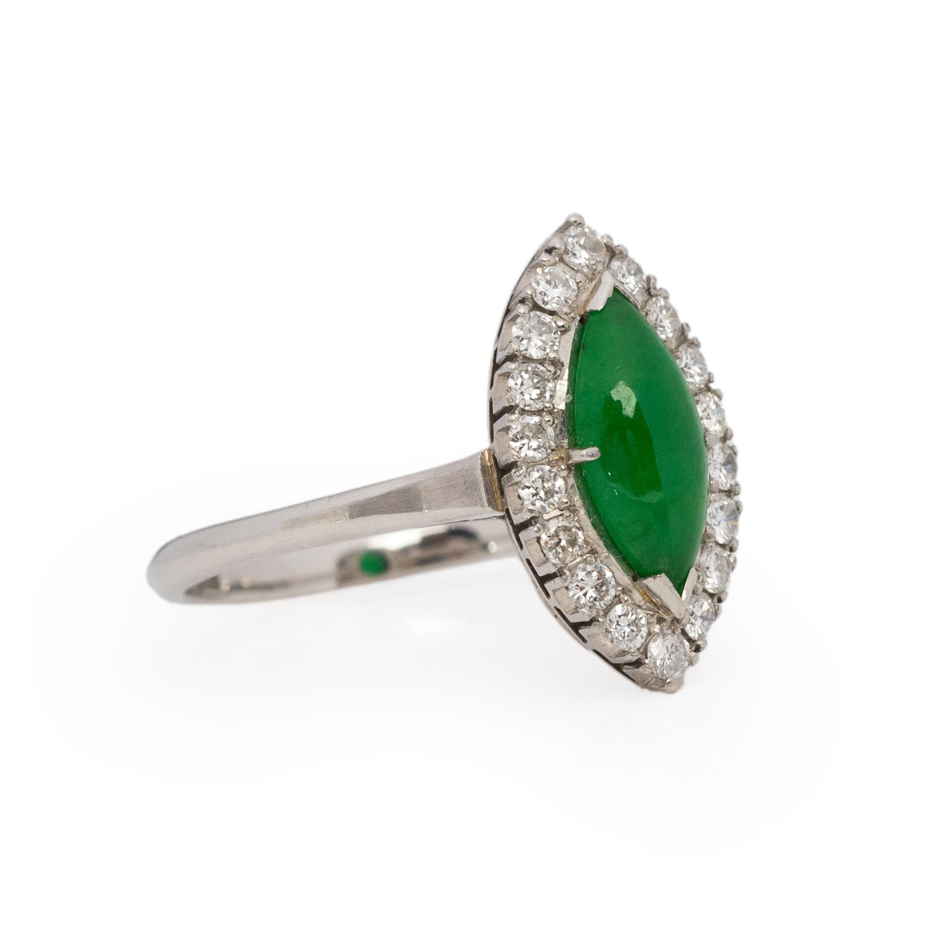 Here we have a vibrant green jade gem that is cut into a marquise. This beautiful piece of jade has a halo of single cut diamonds surrounding it highlighting its breathtaking color. The ring is crafted from platinum, with a simple shank, the gallery