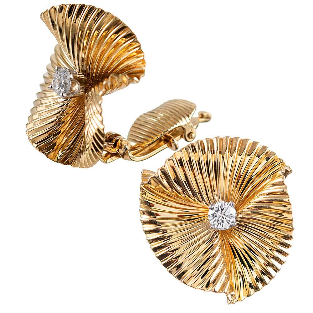 Pleated discs of 14 karat yellow gold are fashioned into a circle and set in the center with a brilliant round diamond. The diamonds weigh .36 carats in total. The earrings appear to mimic a butterfly or bird in flight and are very lively, catching