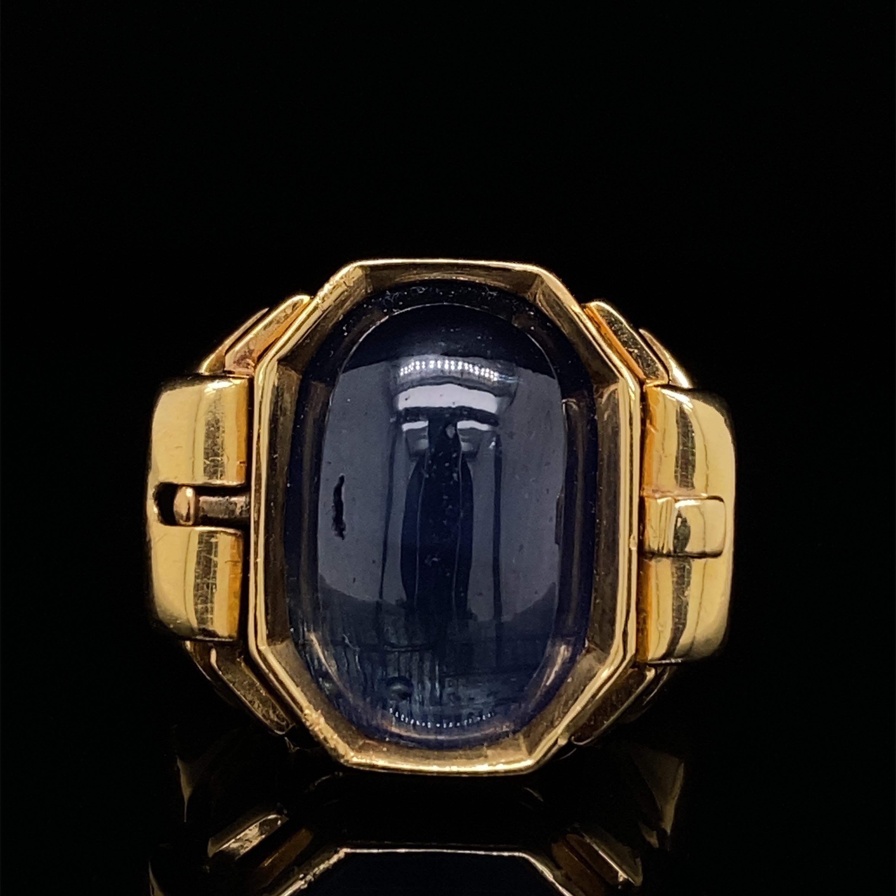 Retrospektiver Saphir-Signetring aus 18 Karat Gelbgold, um 1940.

Dieser ungewöhnliche und raffiniert gearbeitete Ring besteht aus einem tiefblauen Cabochon-Saphir, in den auf der einen Seite ein Siegel eingraviert ist, und einer glatt polierten