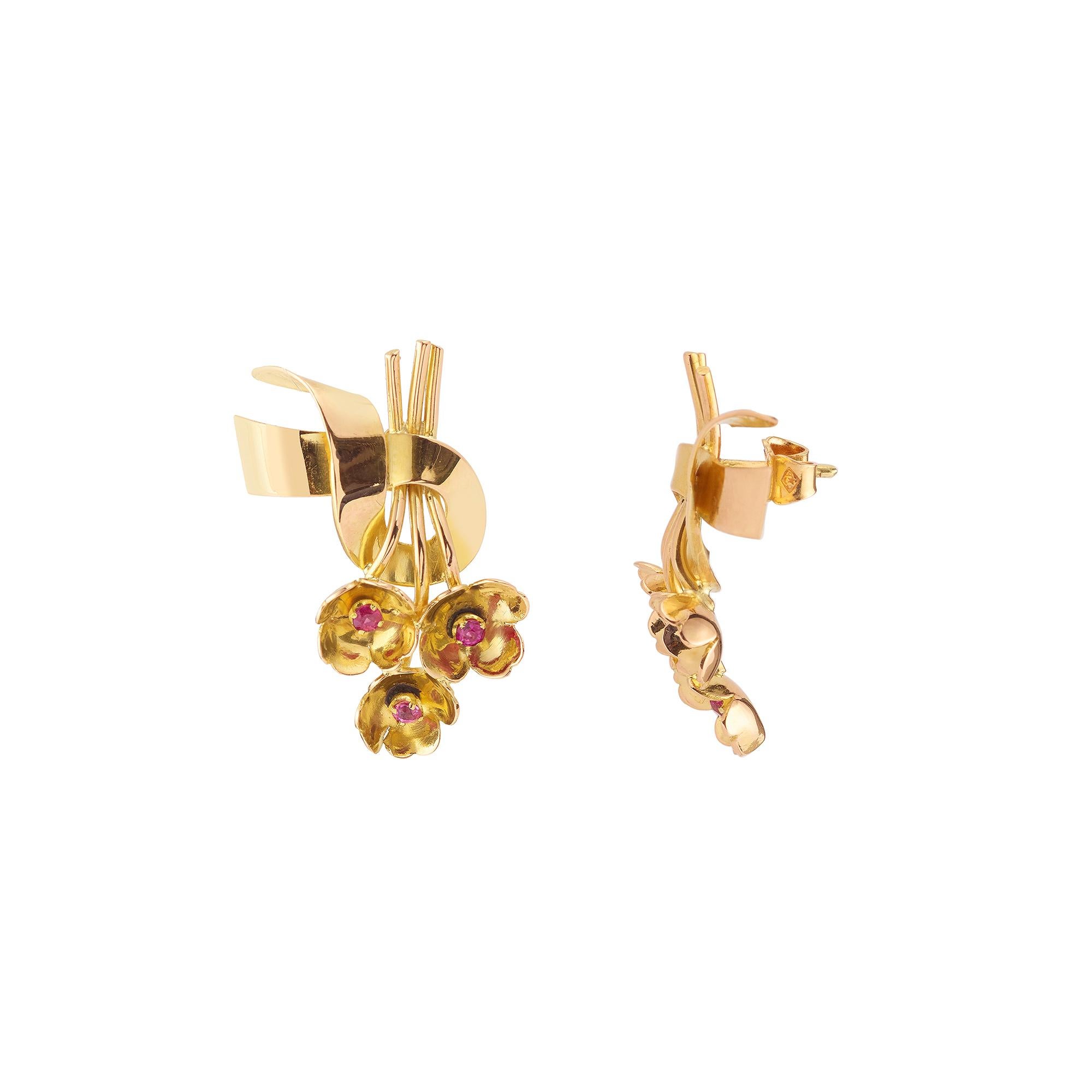 Yellow gold ribbon earrings set with small pink sapphires in the centre of a flower design. The pink sapphires are mostly natural and probably Burmese.

Poucette clasp.

Earrings size : 2.82 x 1.49 cm, (1.960 x 1.585 inch)

Weight of the earrings :