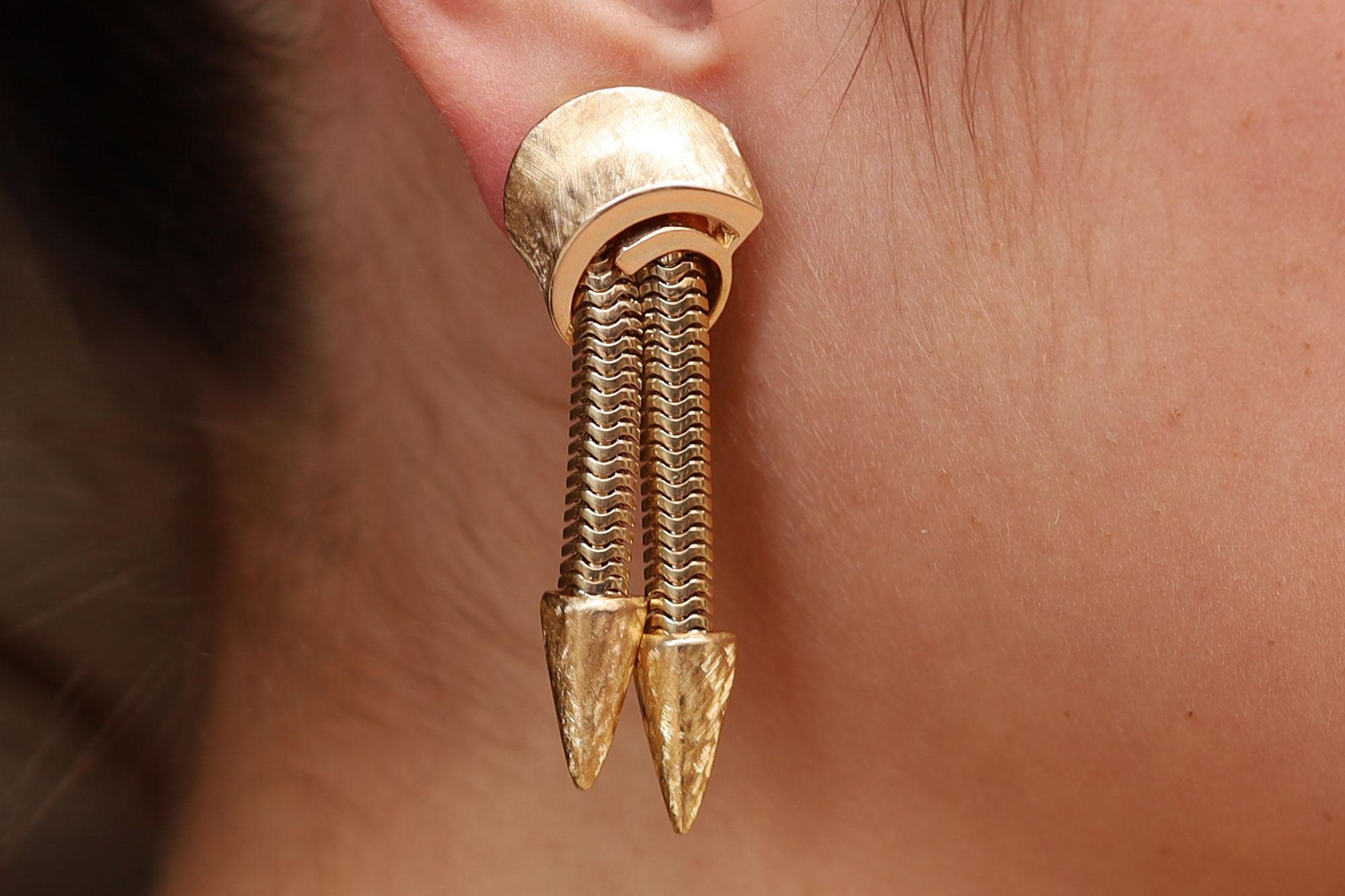 Ces boucles d'oreilles pendantes datant de la fin des années 1940-1950 et de l'époque des fusées rétro du milieu du siècle dernier évoquent l'âge de l'espace. Les chaînes serpent flexibles en or jaune 14 carats sont surmontées d'un capuchon torsadé
