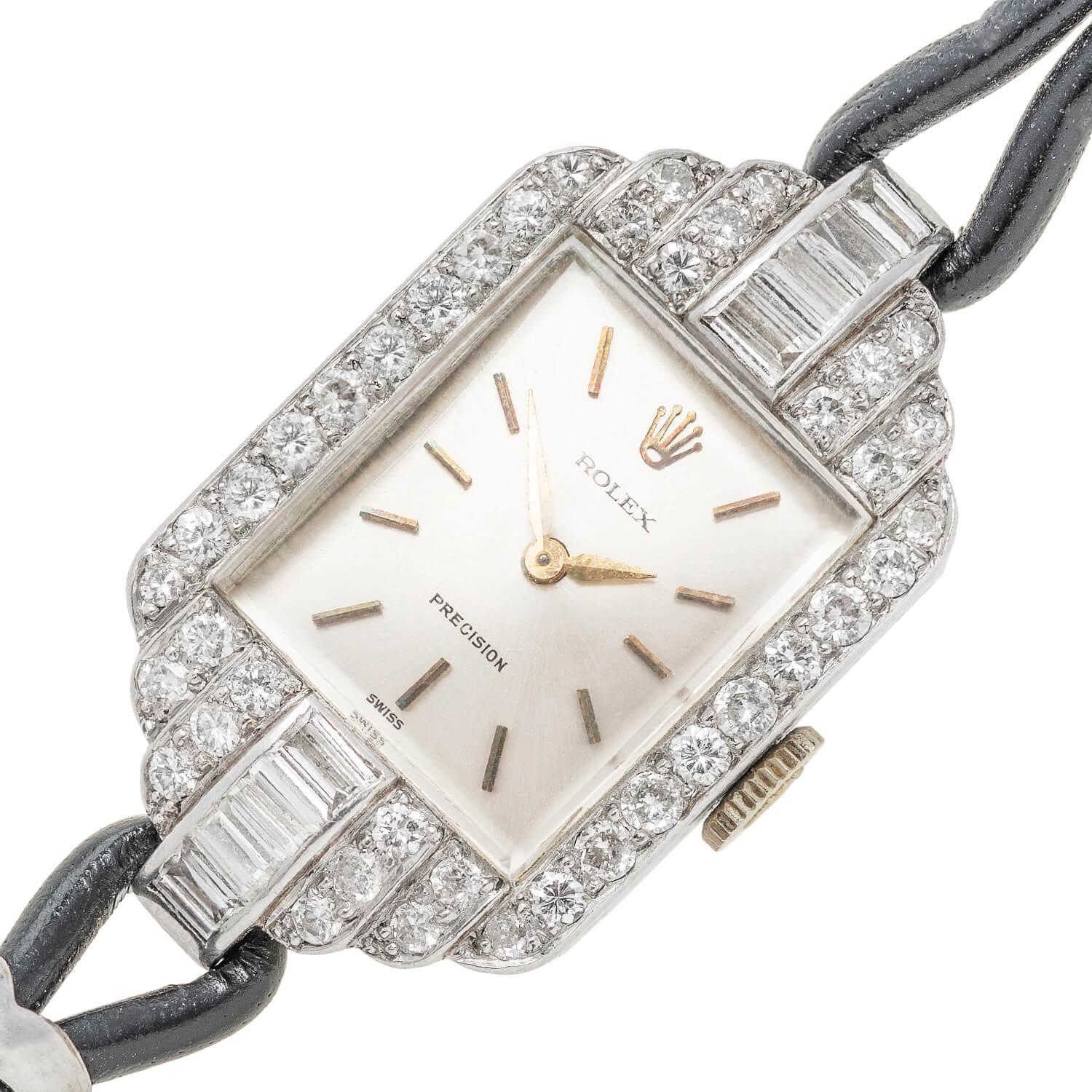 A gorgeous Retro (ca1940s) era Rolex watch! Crafted in platinum, this lovely watch is encrusted with 40 glittering Round Cut and 8 sparkling Baguette diamonds! The approximate 1.75ctw of diamonds adorn the surface of the case in an Art Deco tiered