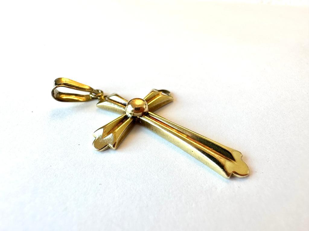 Rétro et en or jaune 18kt, cette merveilleuse croix a été créée en Europe de l'Est. Ce pendentif rétro est sculpté au centre et sur les bords, combinant le style orthodoxe et baroque, ce qui donne une image de la croix comme objet de beauté et non