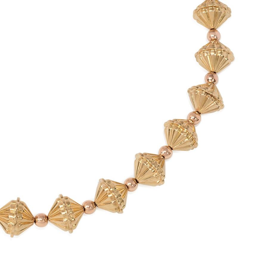A Retro two-color gold necklace comprised of alternating round rose and yellow gold fluted beads, in 18k.
